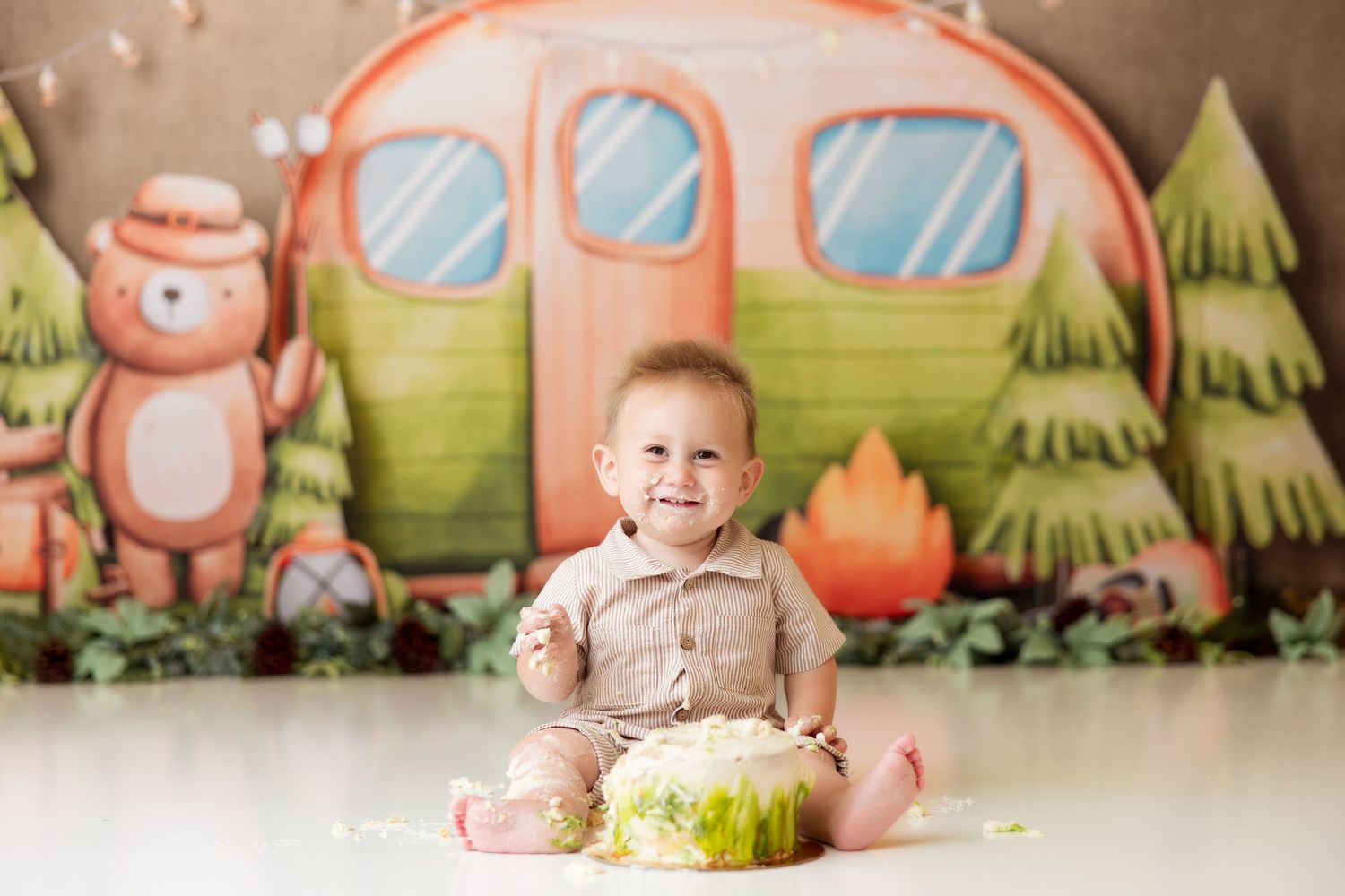 Colorful camping-themed photography setup with cartoon camper and forest details.