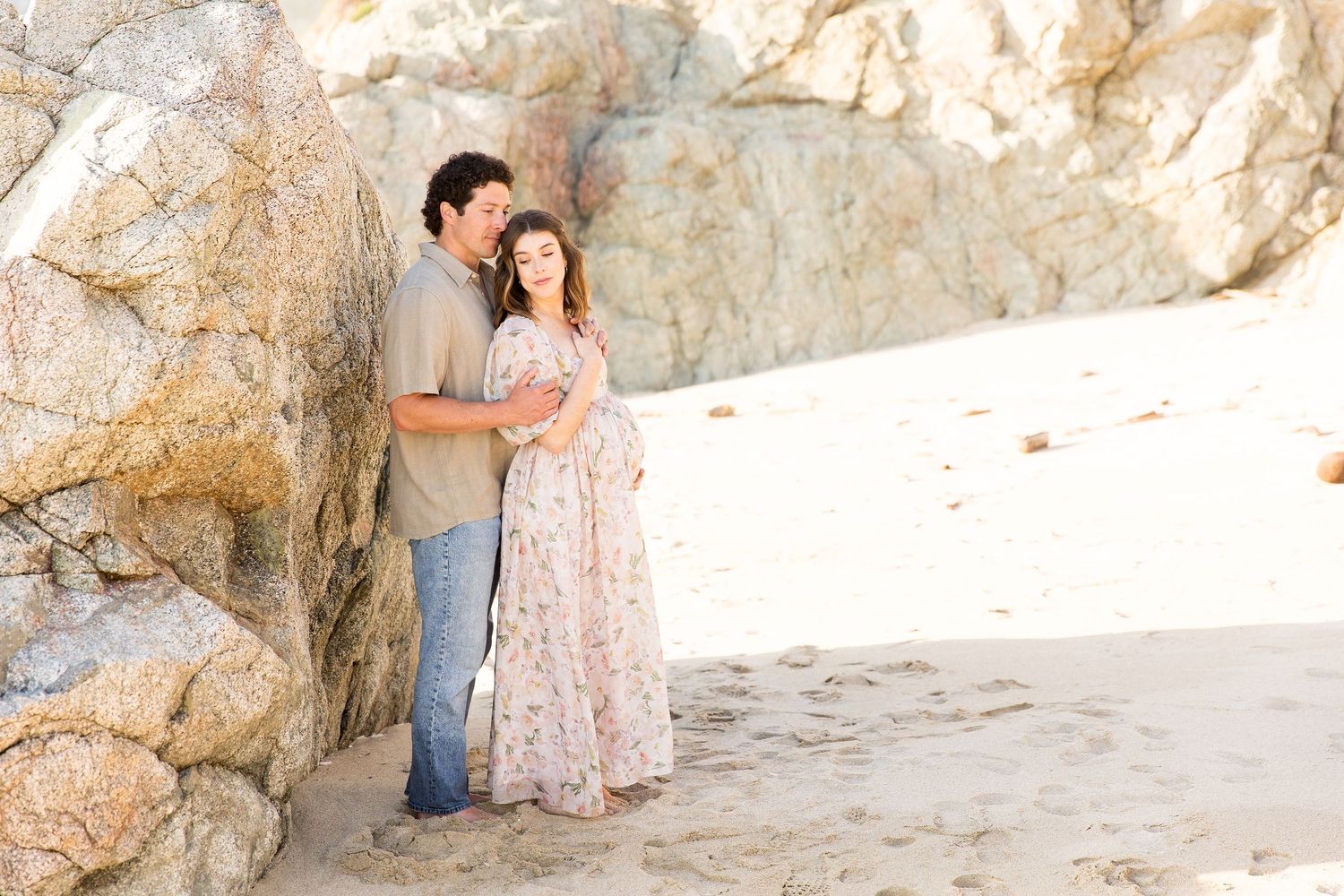 Intimate family photos taken against rocky beach backdrop.