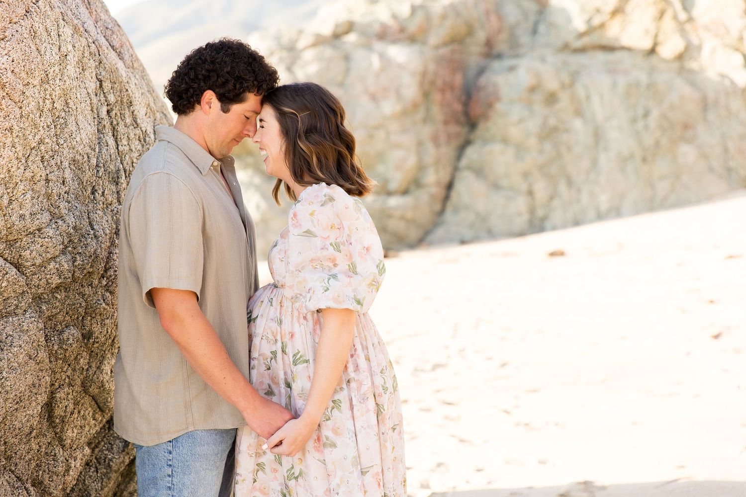Sweet family portraits against natural rock formations on the beach.