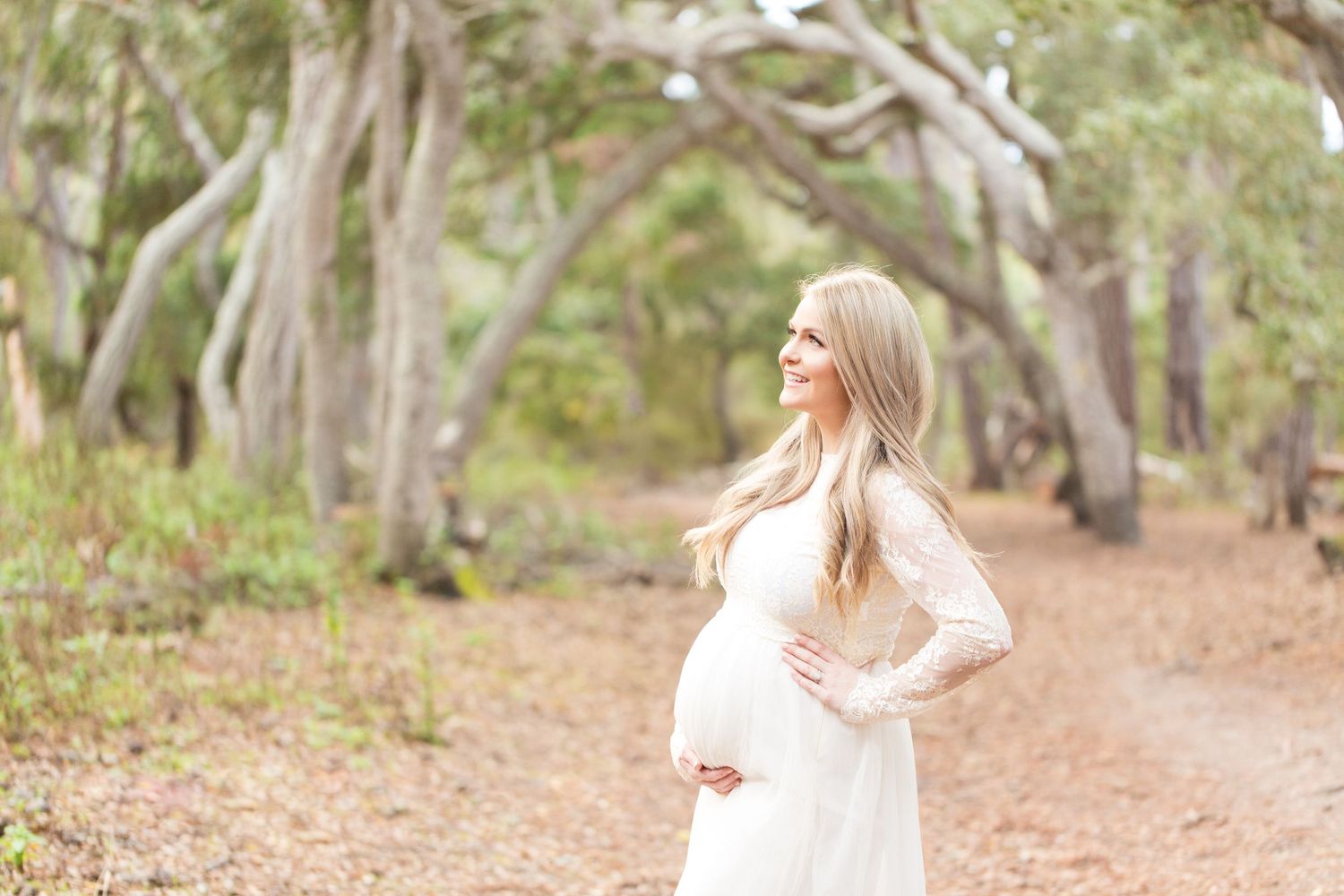 A dreamy forest photoshoot features flowing white fabric and natural autumn lighting.