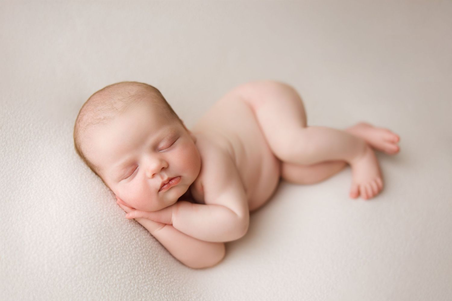 A series of minimalist newborn photography portraits showing peaceful sleeping poses on soft beige backgrounds.