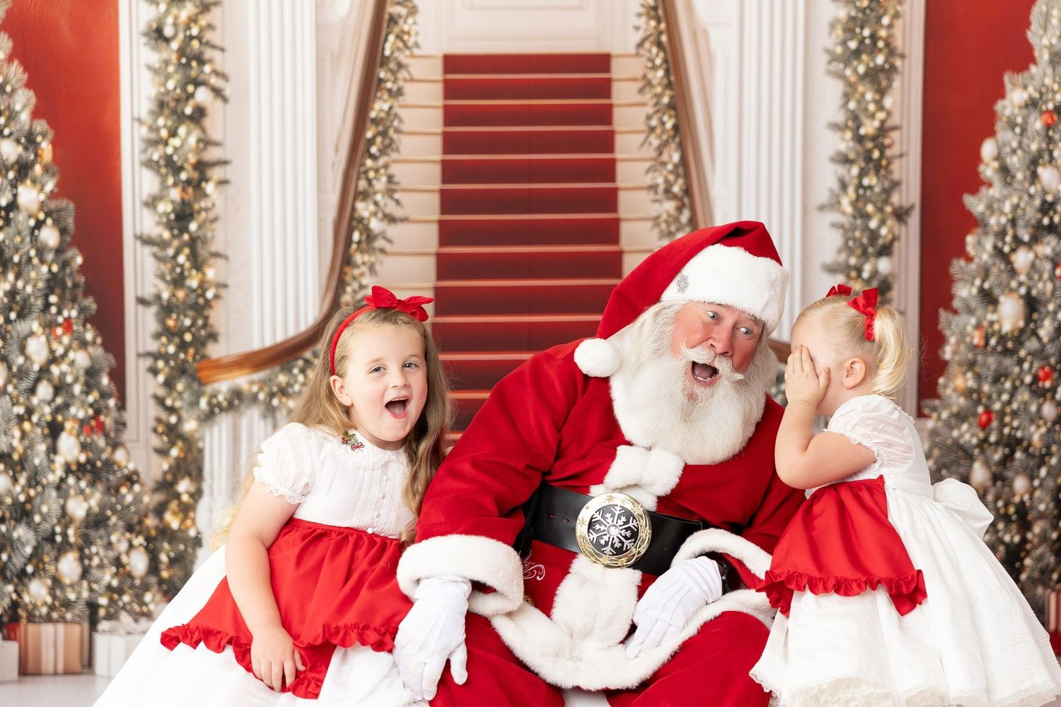 Two sisters in red Christmas dresses laughing with Santa at a Santa mini session in Monterey