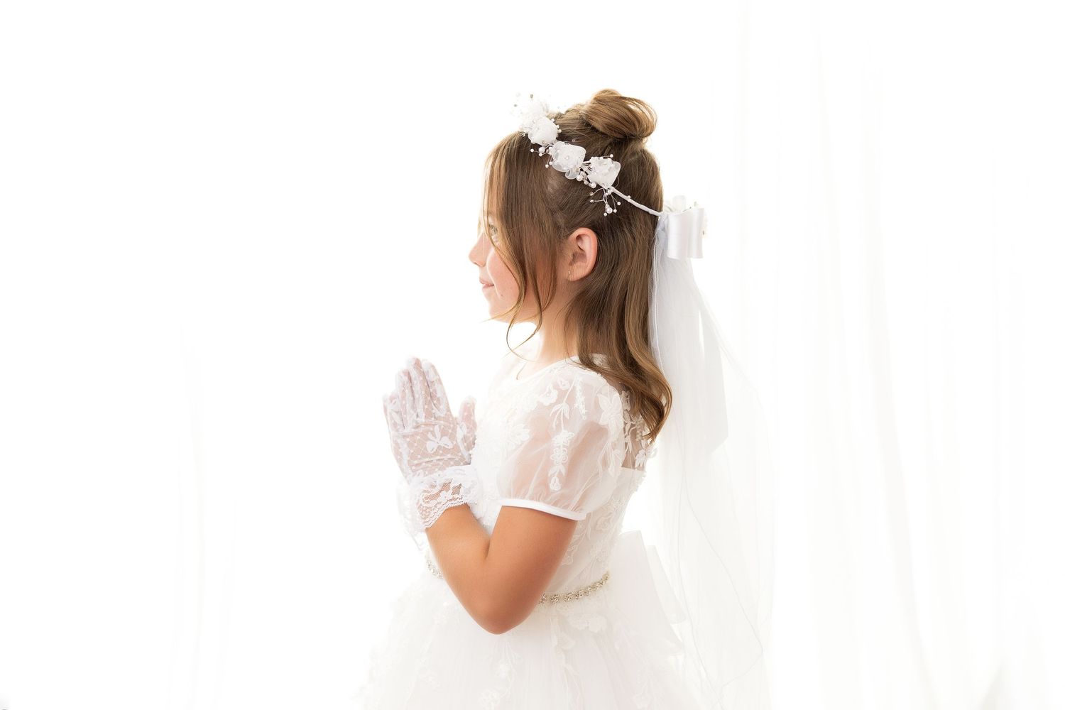 Wedding dress details showing delicate lace and textured fabric in a white flowing gown with feminine details.
