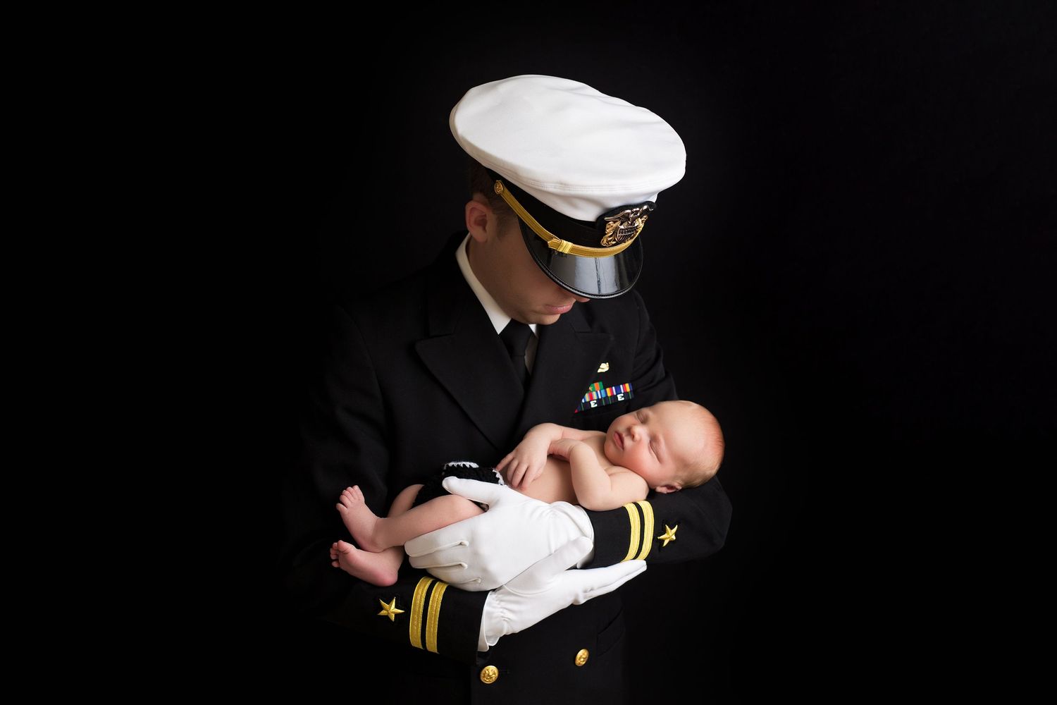 A series of seven similar photographs showing a person in naval uniform holding and posing with a baby in white clothing.