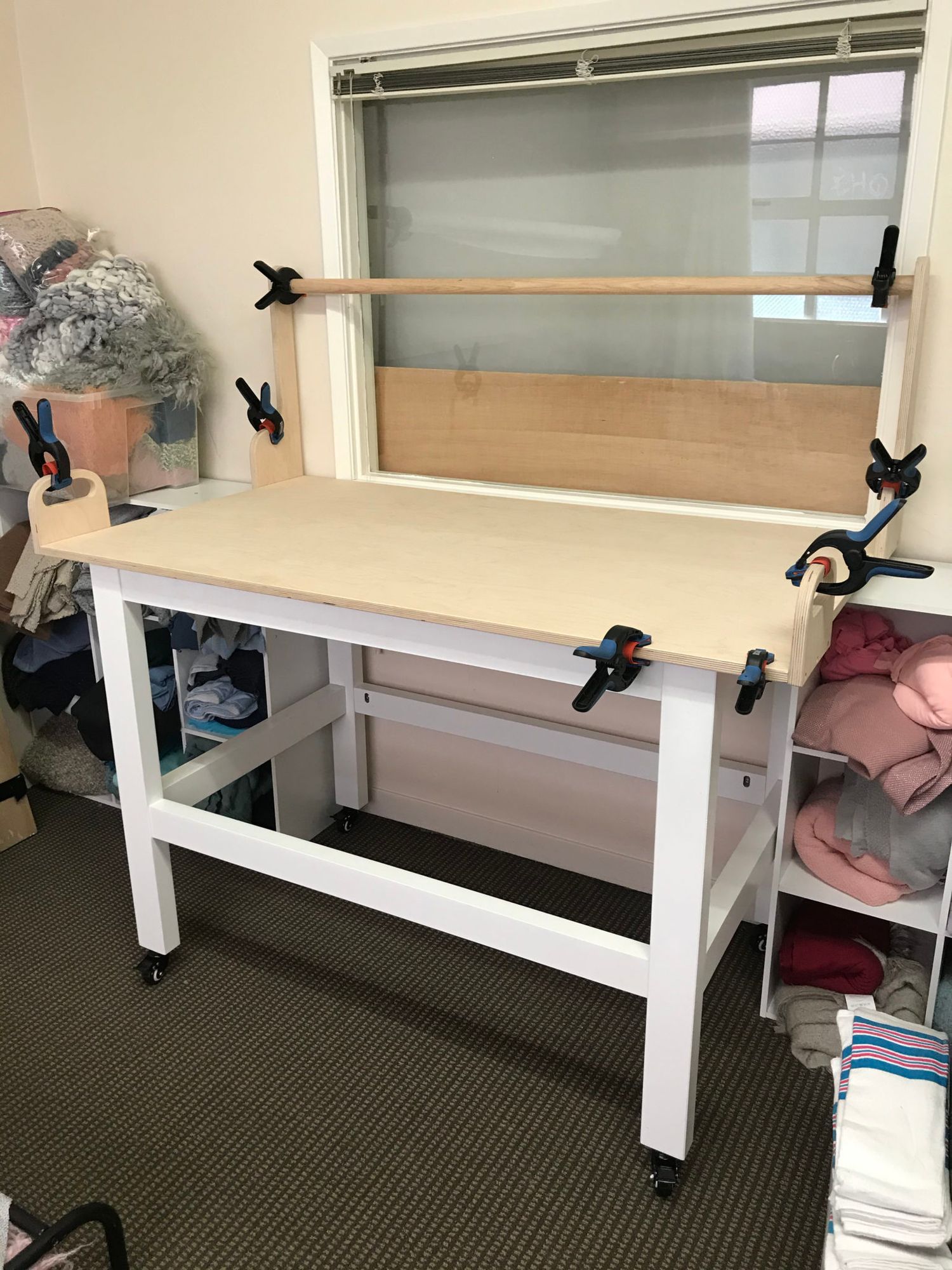 White adjustable height treatment table with rolling casters shown from different angles in an office setting.