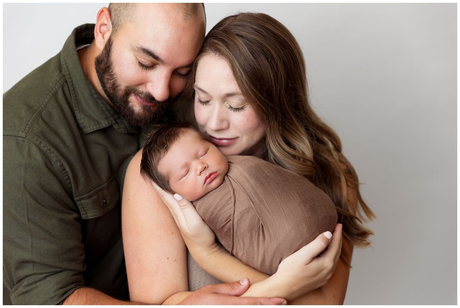 A couple shares an intimate embrace while sitting together in a romantic photoshoot session.