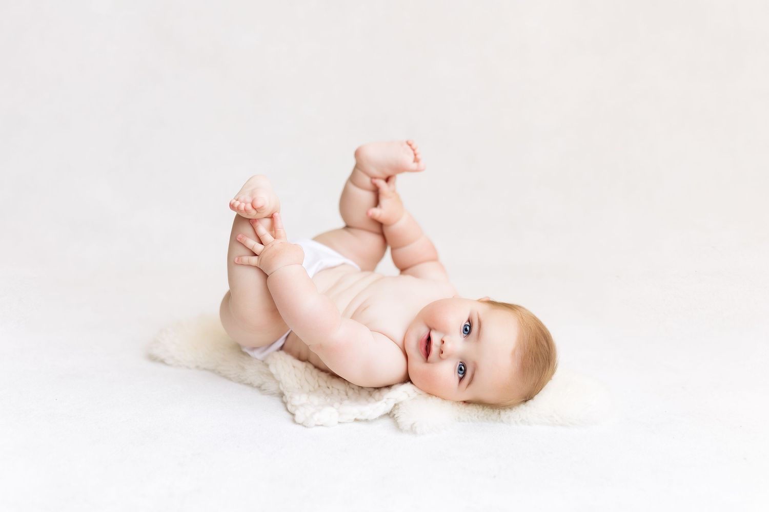 6 month old chunky baby boy, simple white background, photography studio in Monterey
