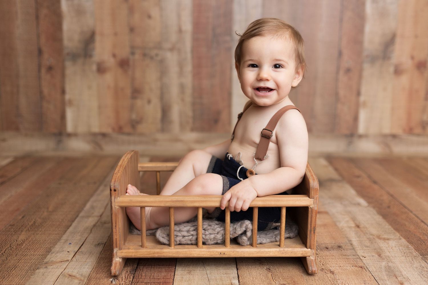 1 year old boy studio photo session in pacific grove, boy wearing old timey outfit, sitting in wood crib