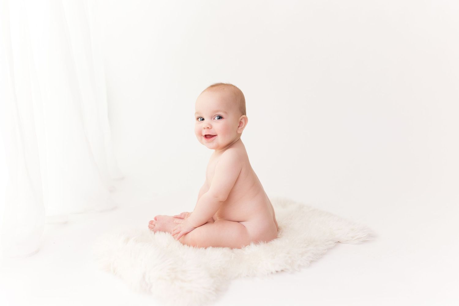 Simple minimalist baby portrait on white background in natural light.