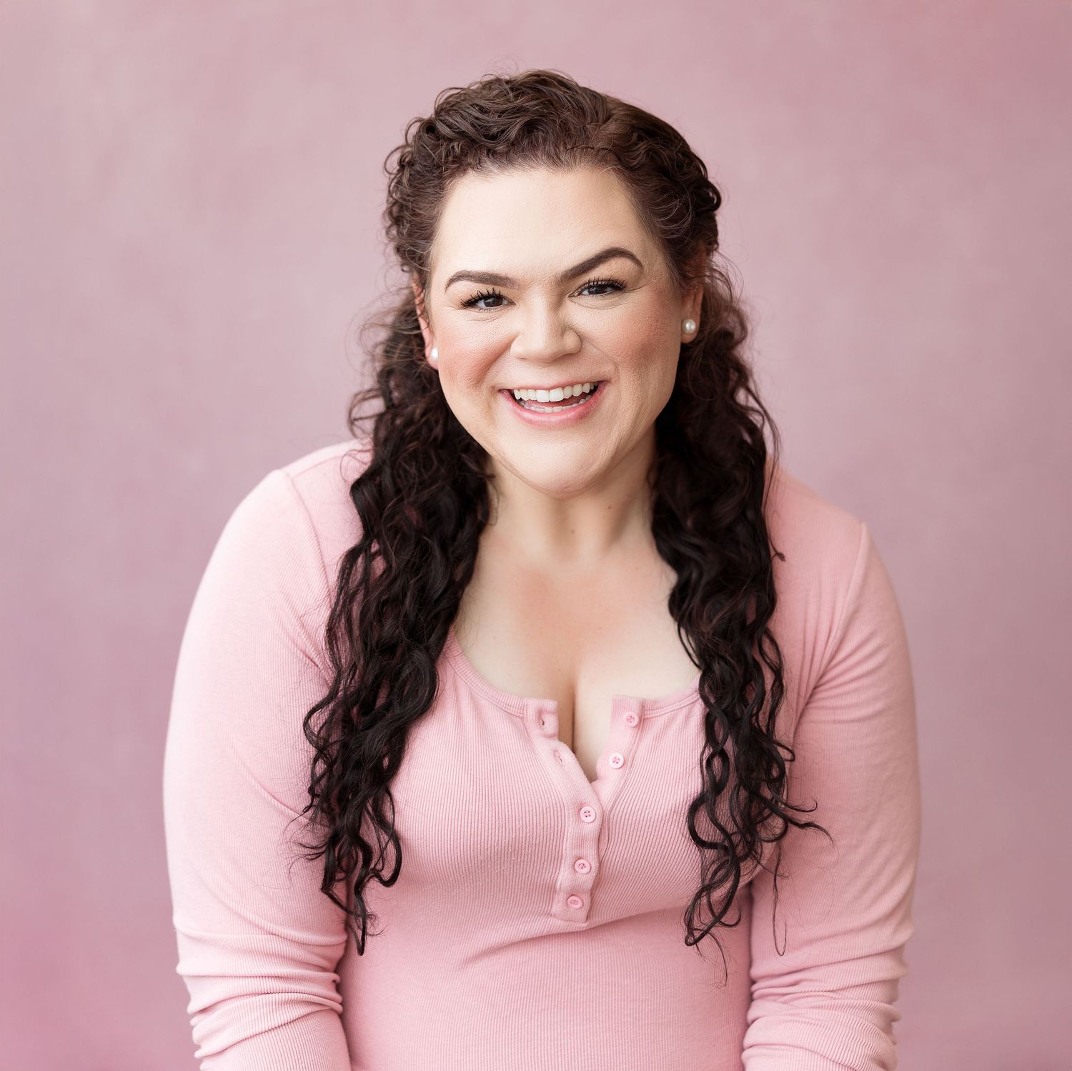A series of pink-toned portraits showing joyful expressions and curly dark hair against a soft studio backdrop.