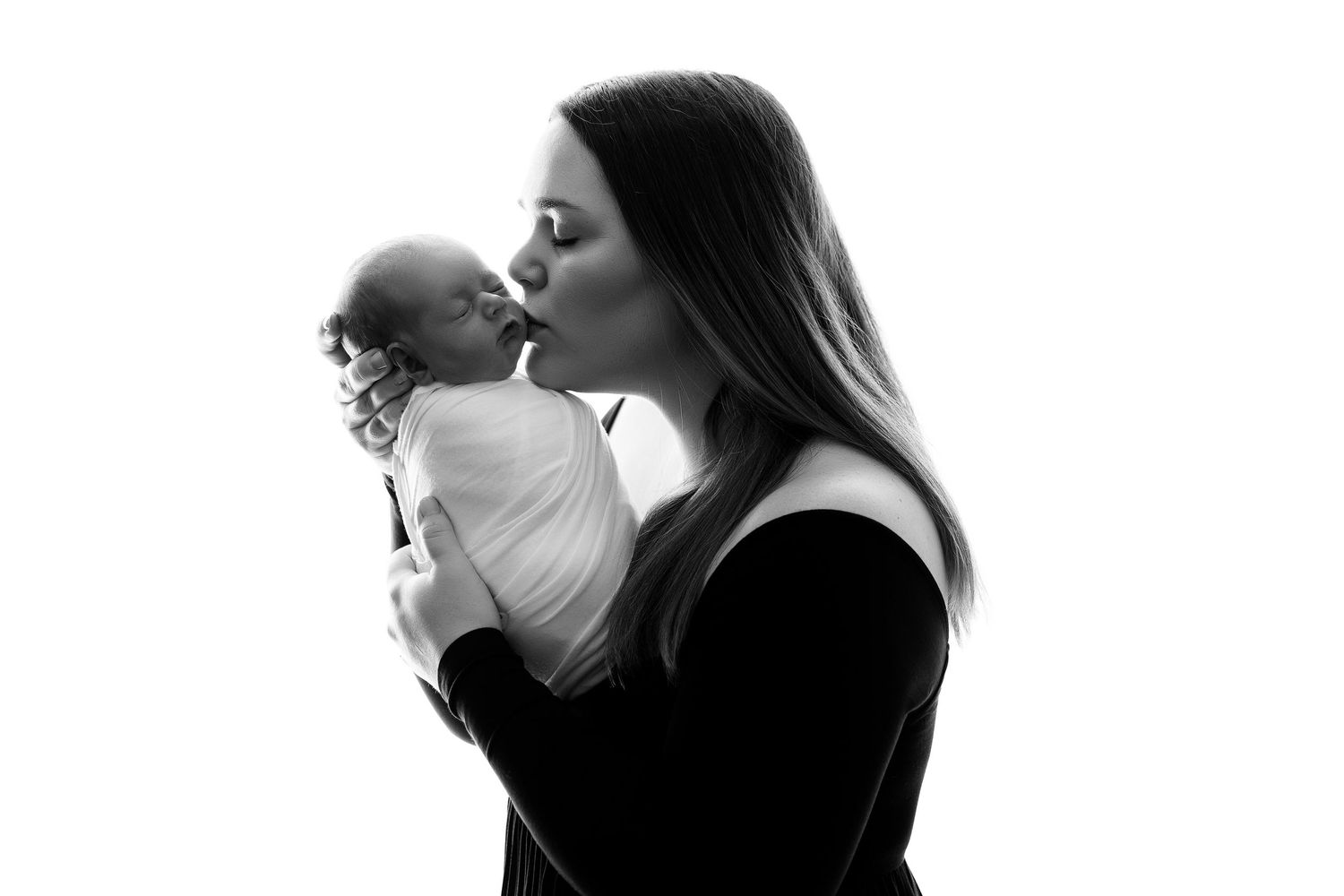 Black and white silhouette of tender moment between parent and baby.
