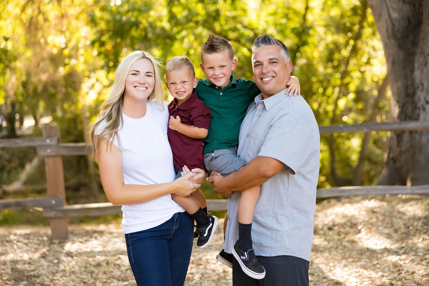 Family embracing and laughing together during outdoor photo session.