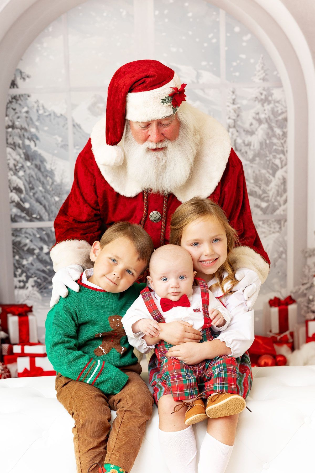 Three siblings with baby brother sitting with Santa for Christmas photos near Carmel