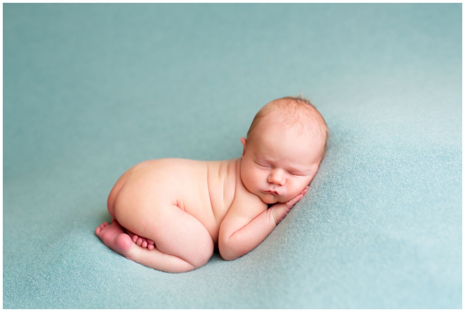 Seven connected images showing a sleeping newborn baby in different peaceful poses on a soft turquoise backdrop.