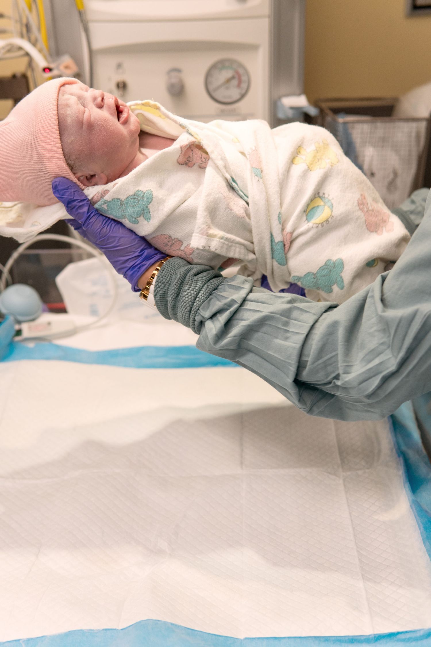 Medical professional in protective gear performing a medical procedure on a patient in a clinical setting.