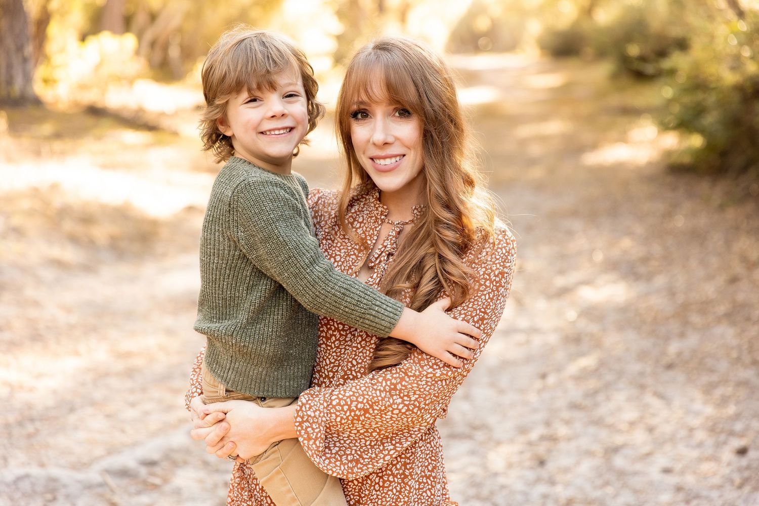 Warm autumn family photos with golden sunlight filtering through trees.