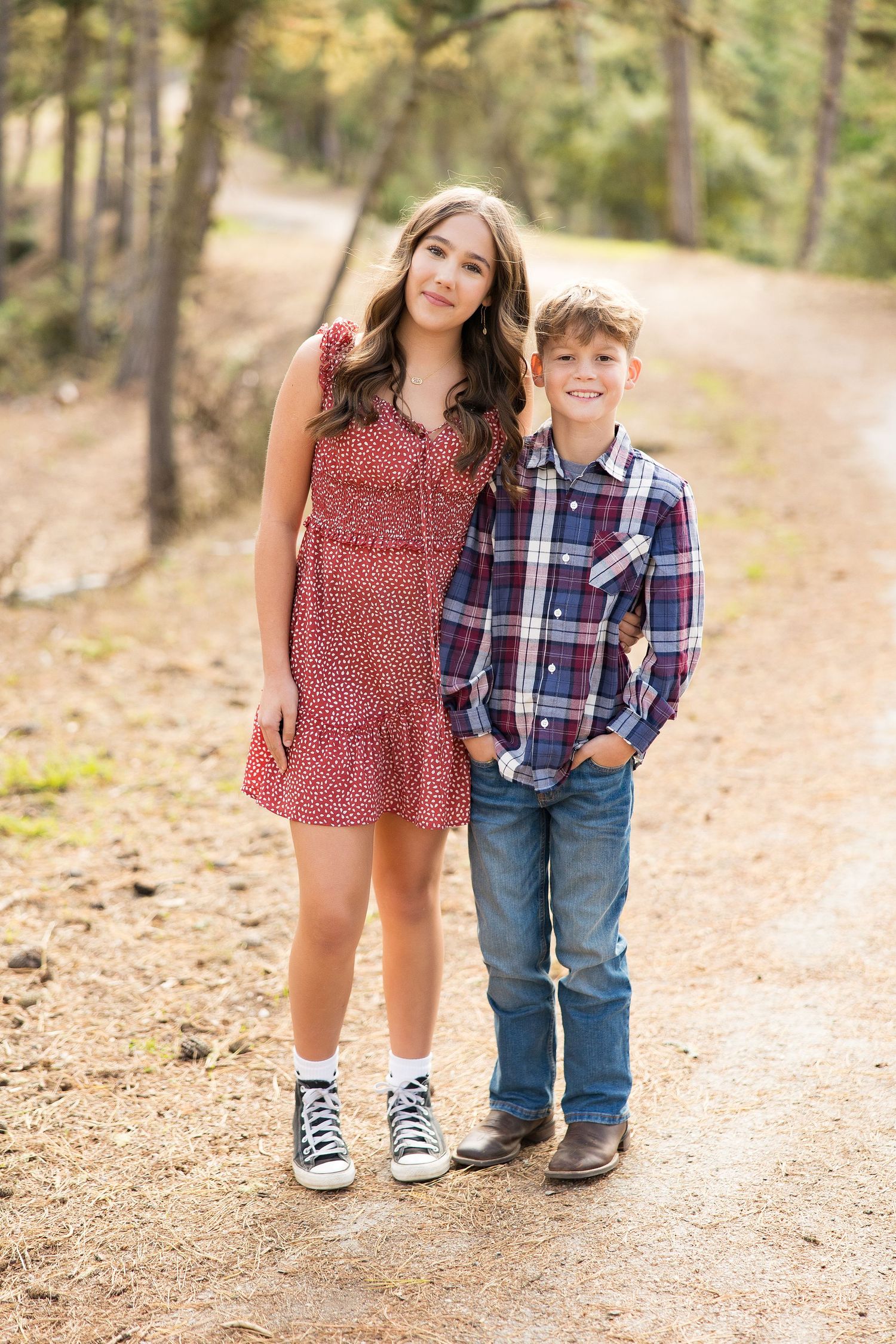 A portrait series showing cropped views focusing on shoes, legs and feet of two people standing on a dirt path in a forest.