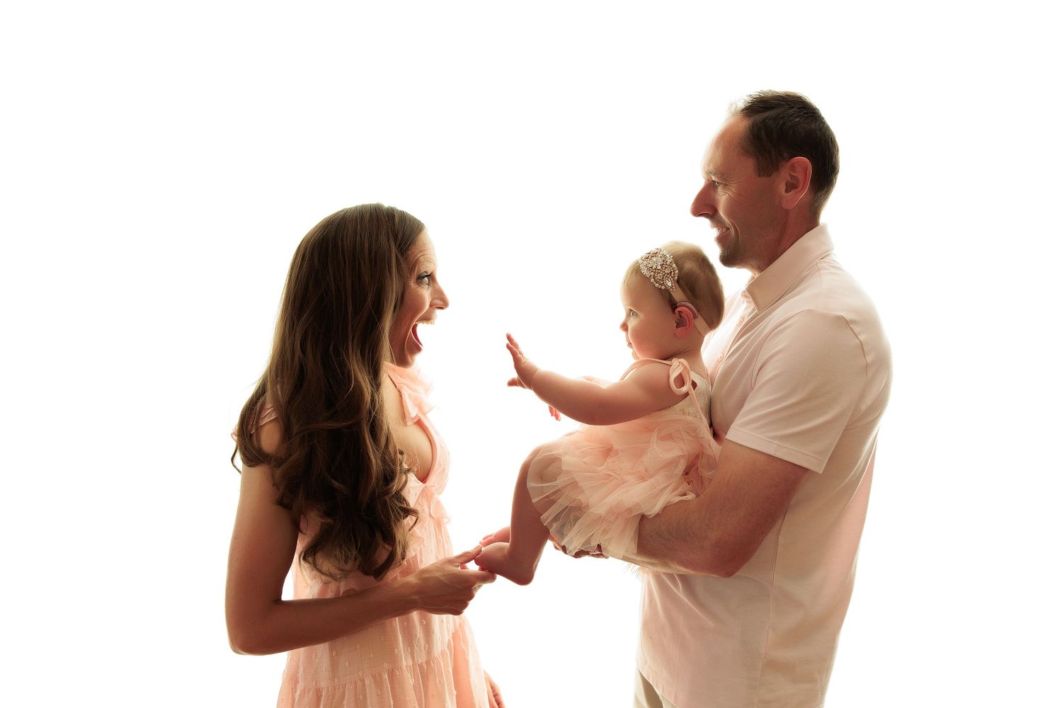 Family photography series in soft pink and white outfits against neutral background.