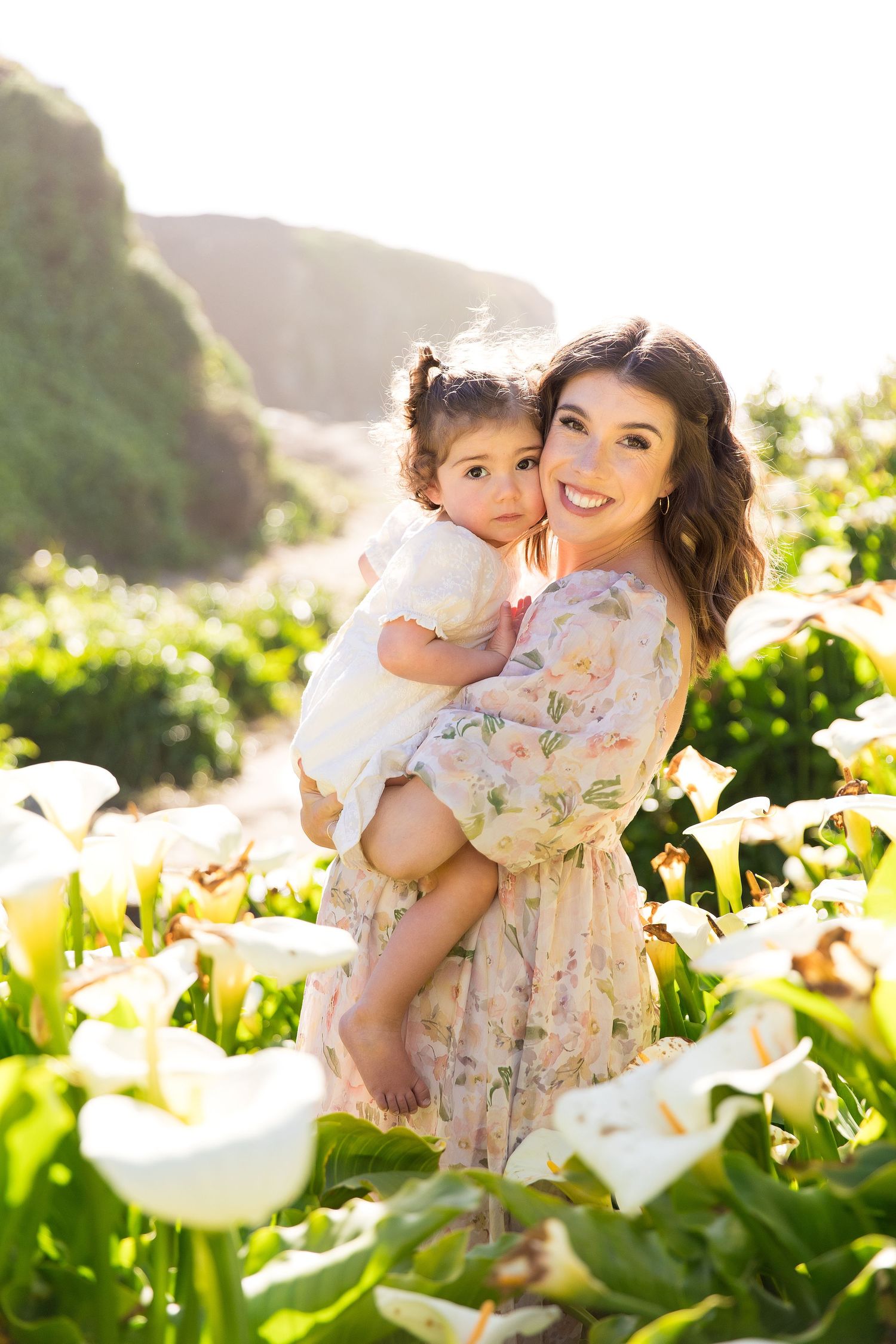 Beautiful family portraits among white calla lilies during sunset.