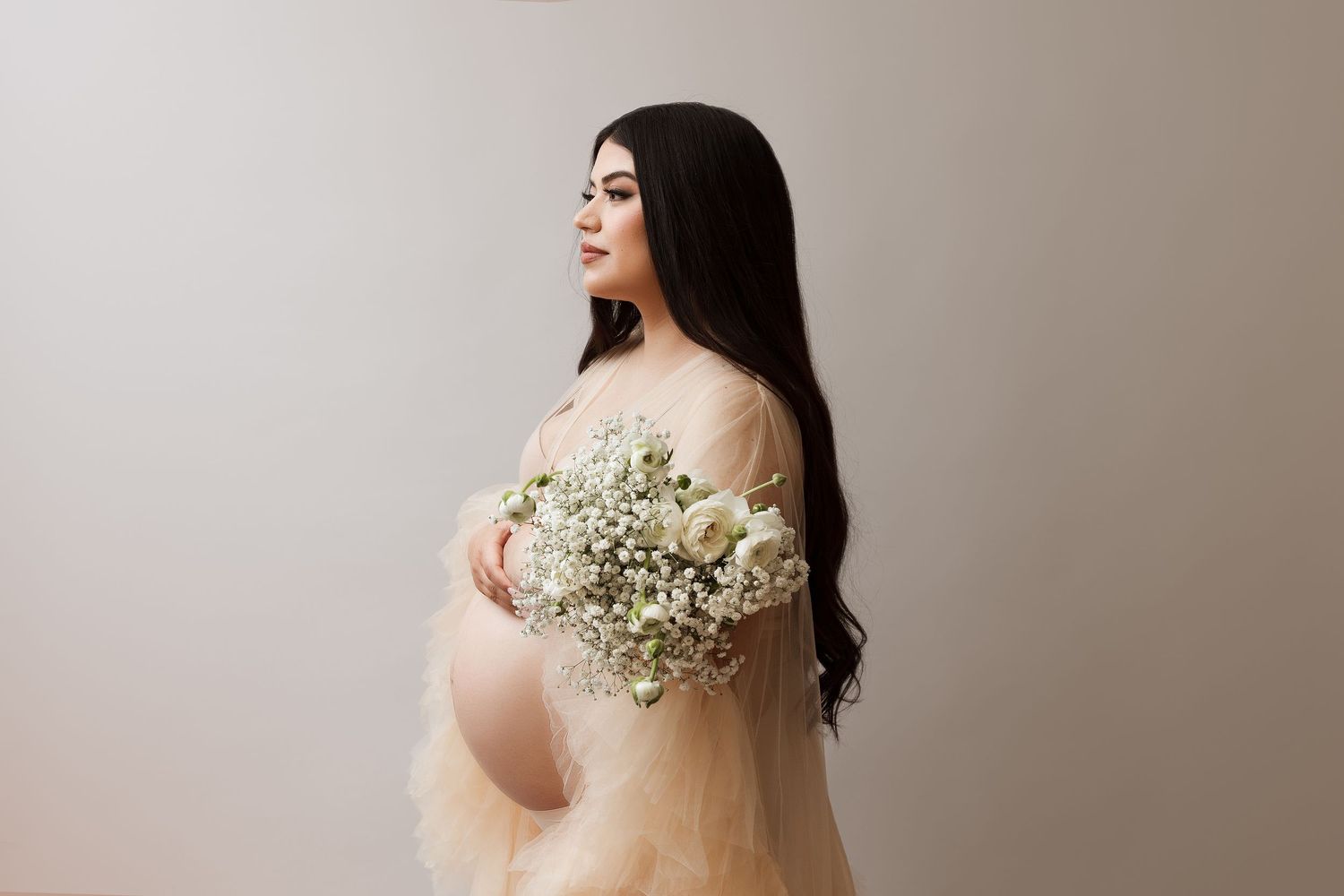 Dreamy maternity photo with baby's breath bouquet and blush tulle gown.