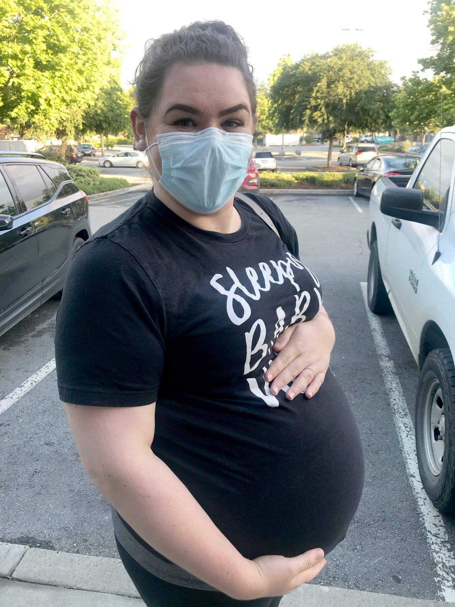 A person wearing a black t-shirt poses in a parking lot on a sunny day, showing their outfit from different angles.