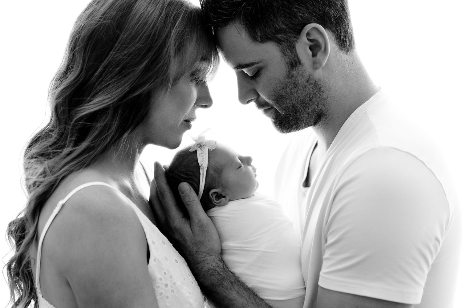 Intimate black and white couple portraits showing tender romantic moments against neutral background.