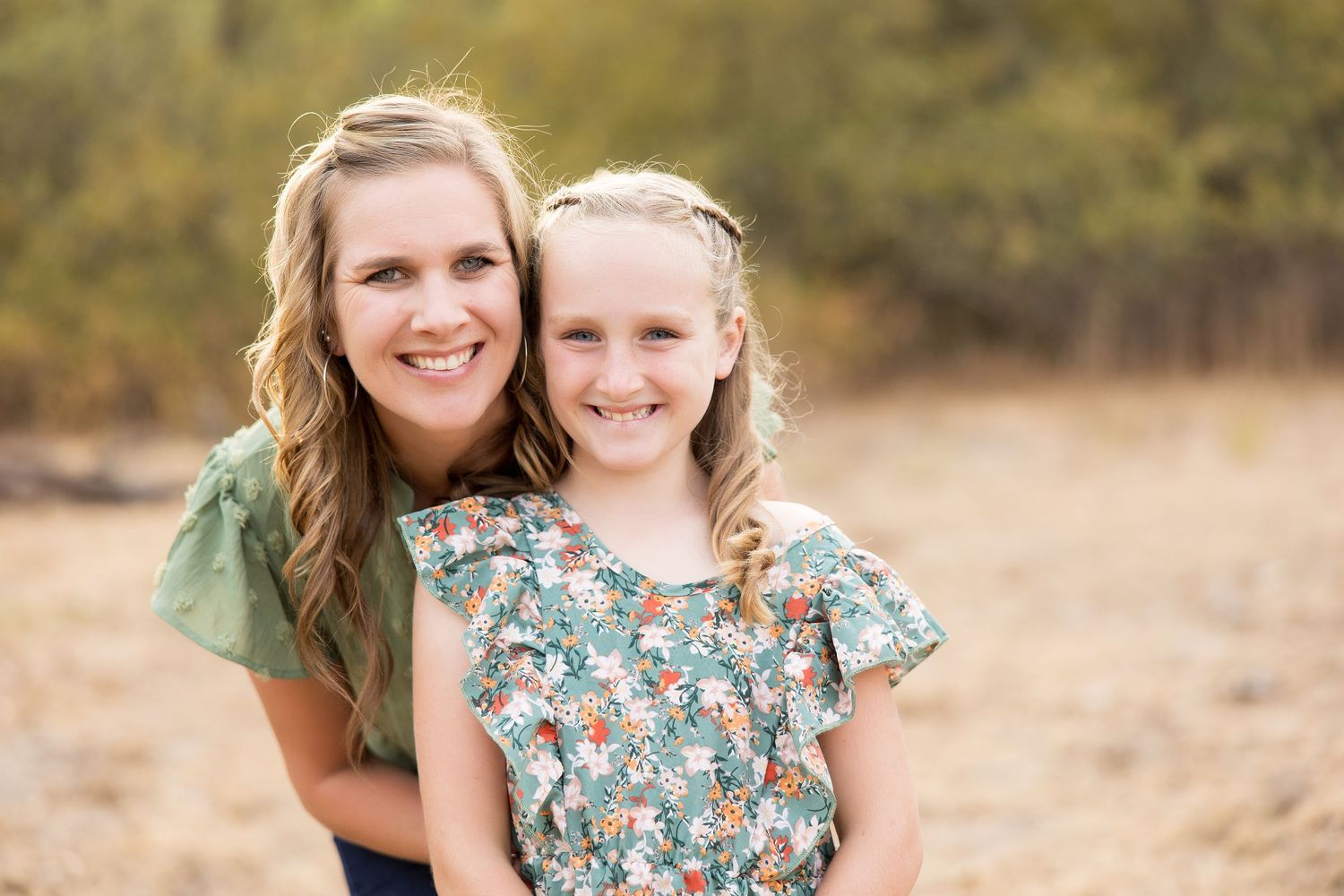 Portrait of parent and child sharing a joyful moment outdoors.