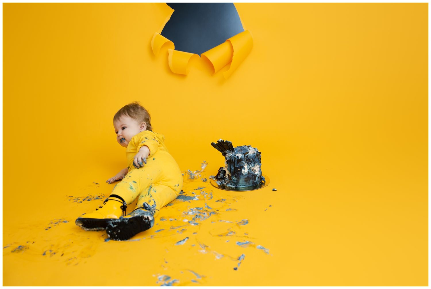 Graduation themed photo with cap and scattered decorations on bright yellow backdrop.