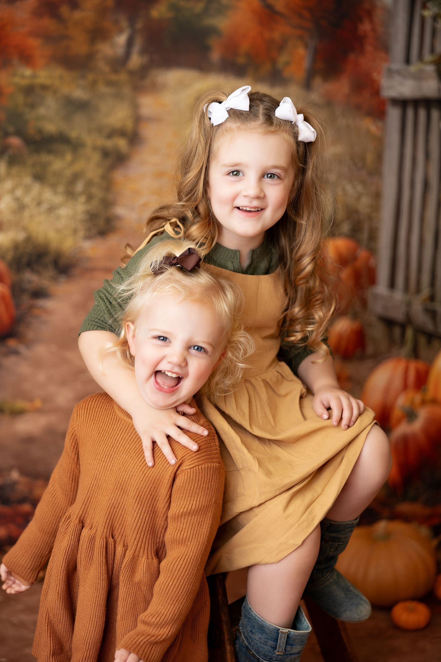 Autumn themed portrait session with children in warm earth tones against fall backdrop.