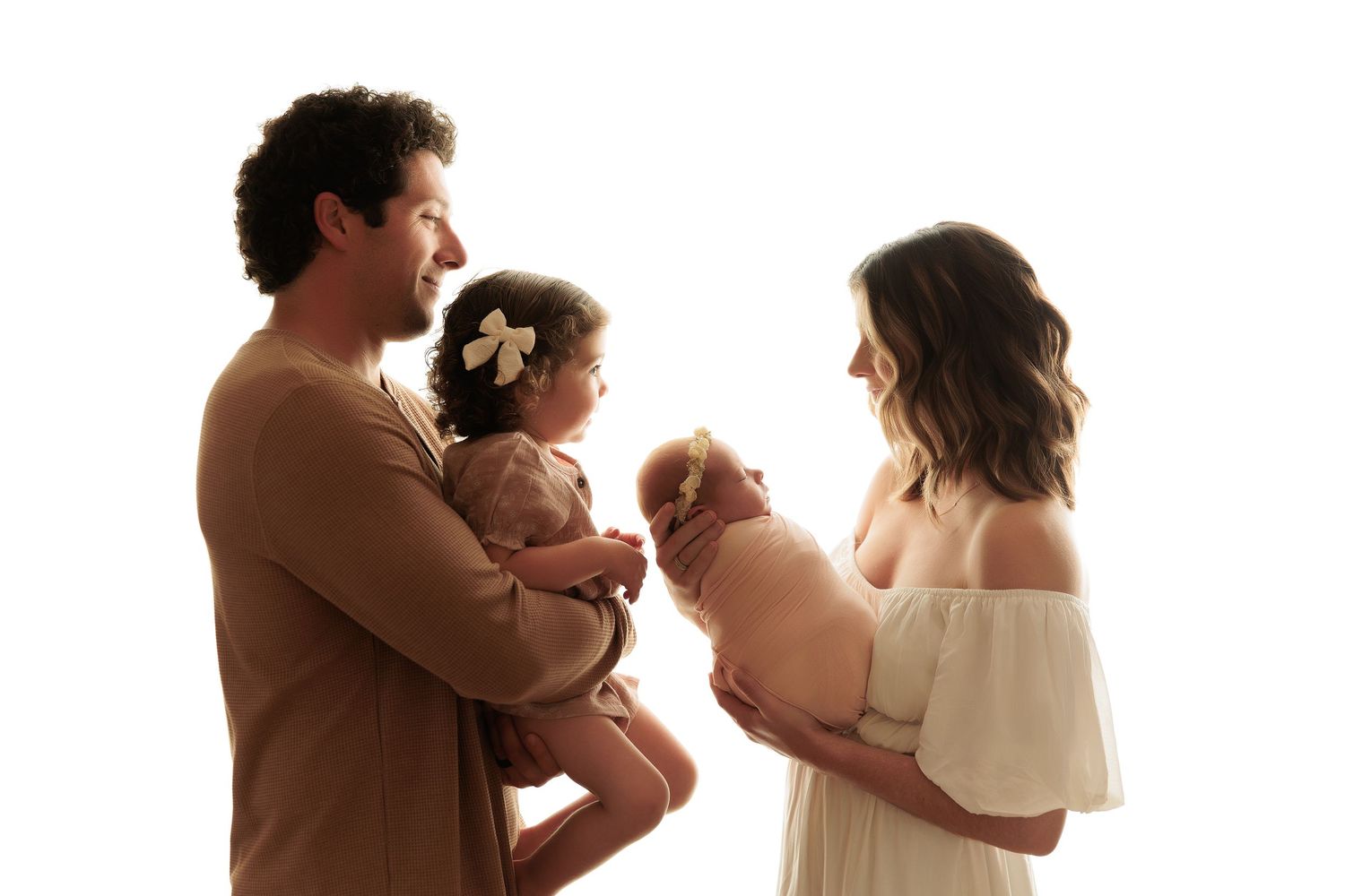 Professional studio photos showing tender family moments in neutral tones.