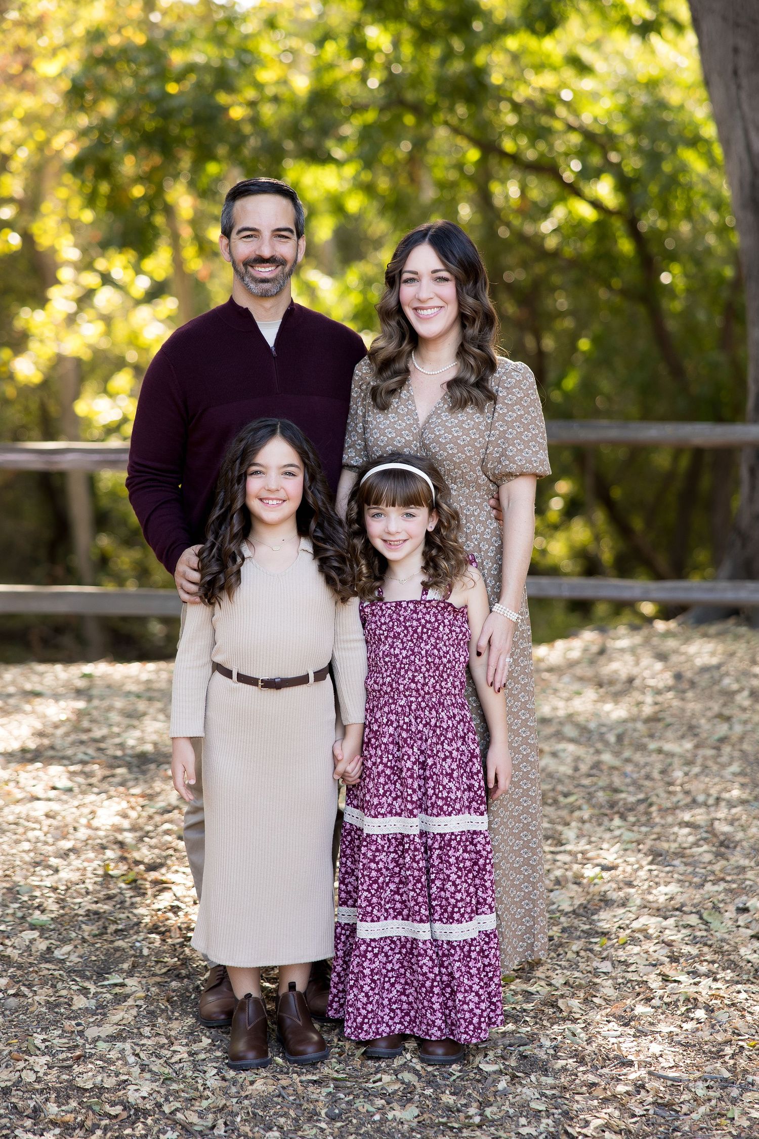 Autumn family portrait in coordinated outfits among fallen leaves in Vasona.