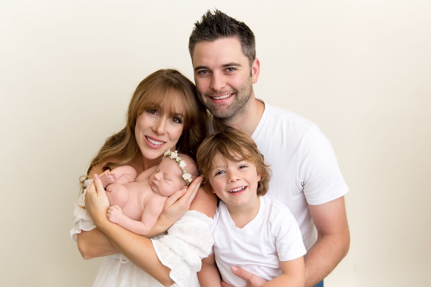 Family in white shirts sharing loving embraces during casual portrait session.