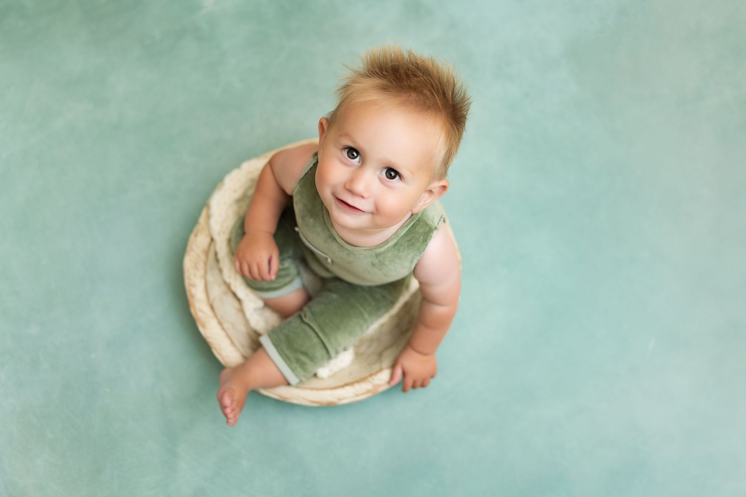 Mint green background creates a soft, dreamy atmosphere for milestone photography.