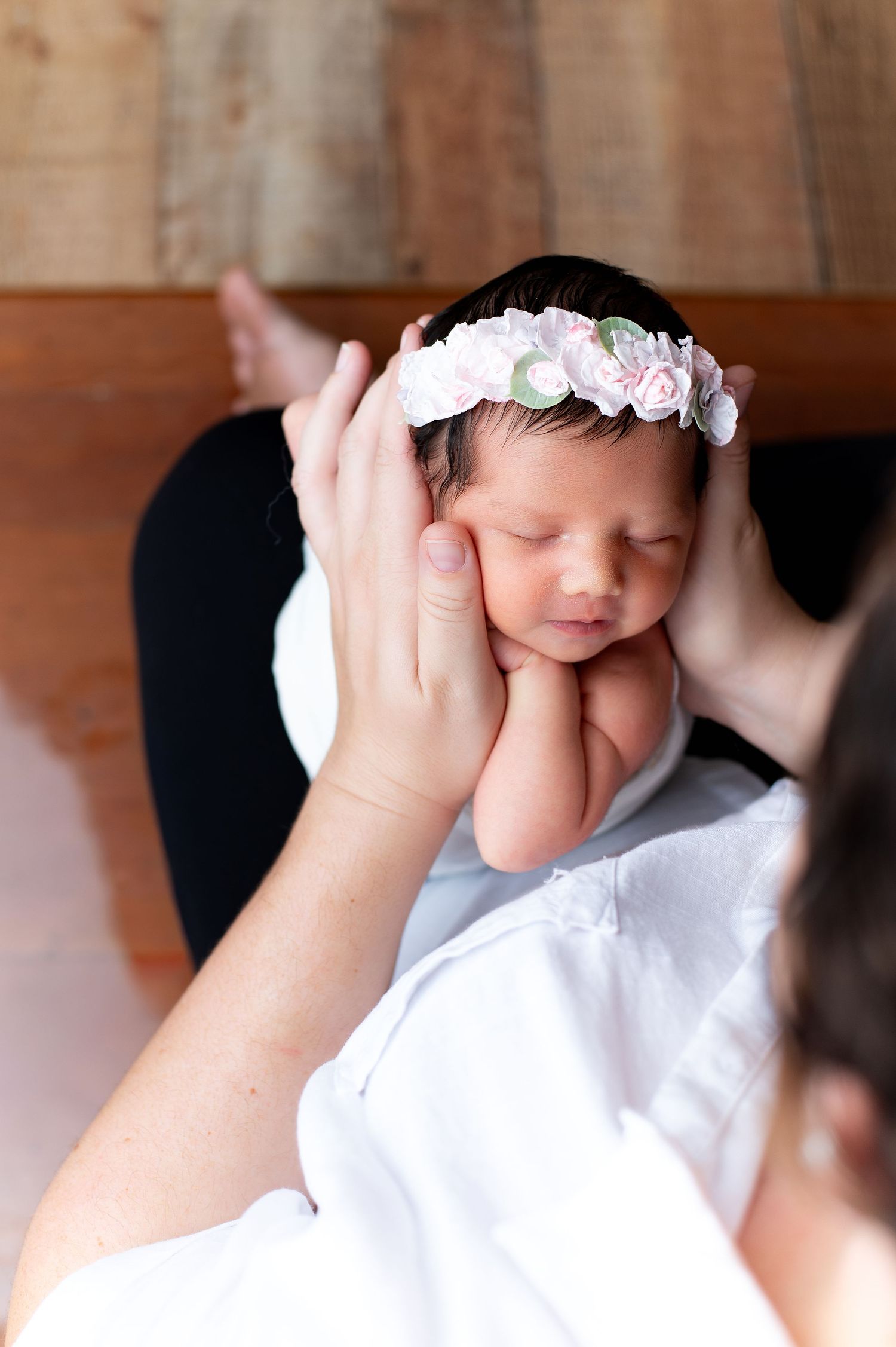 A child wearing a white floral crown and white clothing rests their head on their hands in a series of photos.