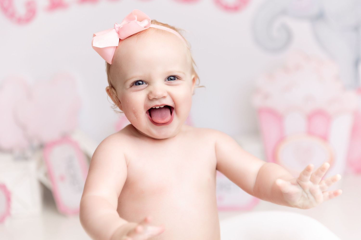 Joyful studio portrait with pink and silver backdrop showing excited expression.