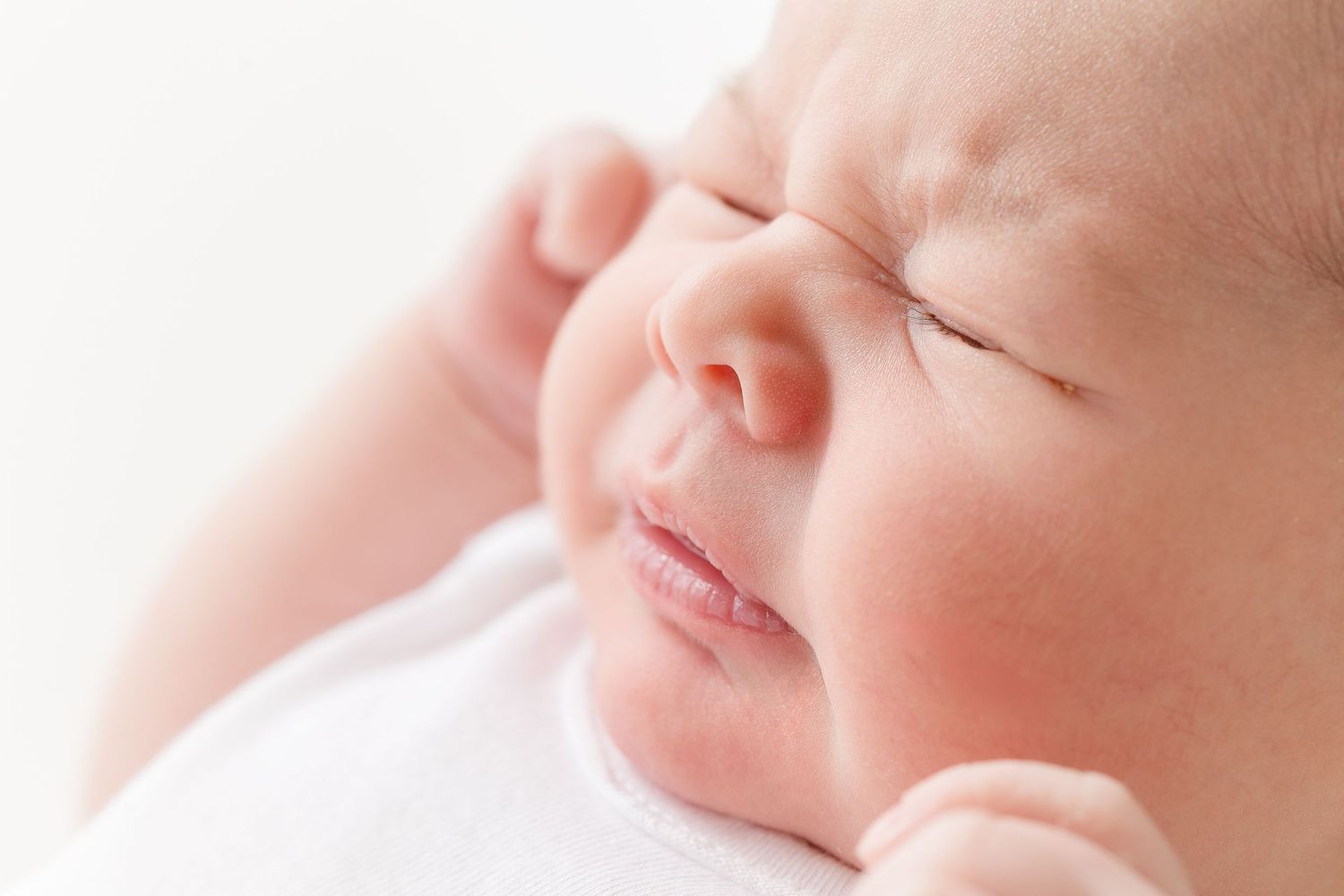 Close-up view of a sleeping baby's face with soft, rosy skin in peaceful slumber.