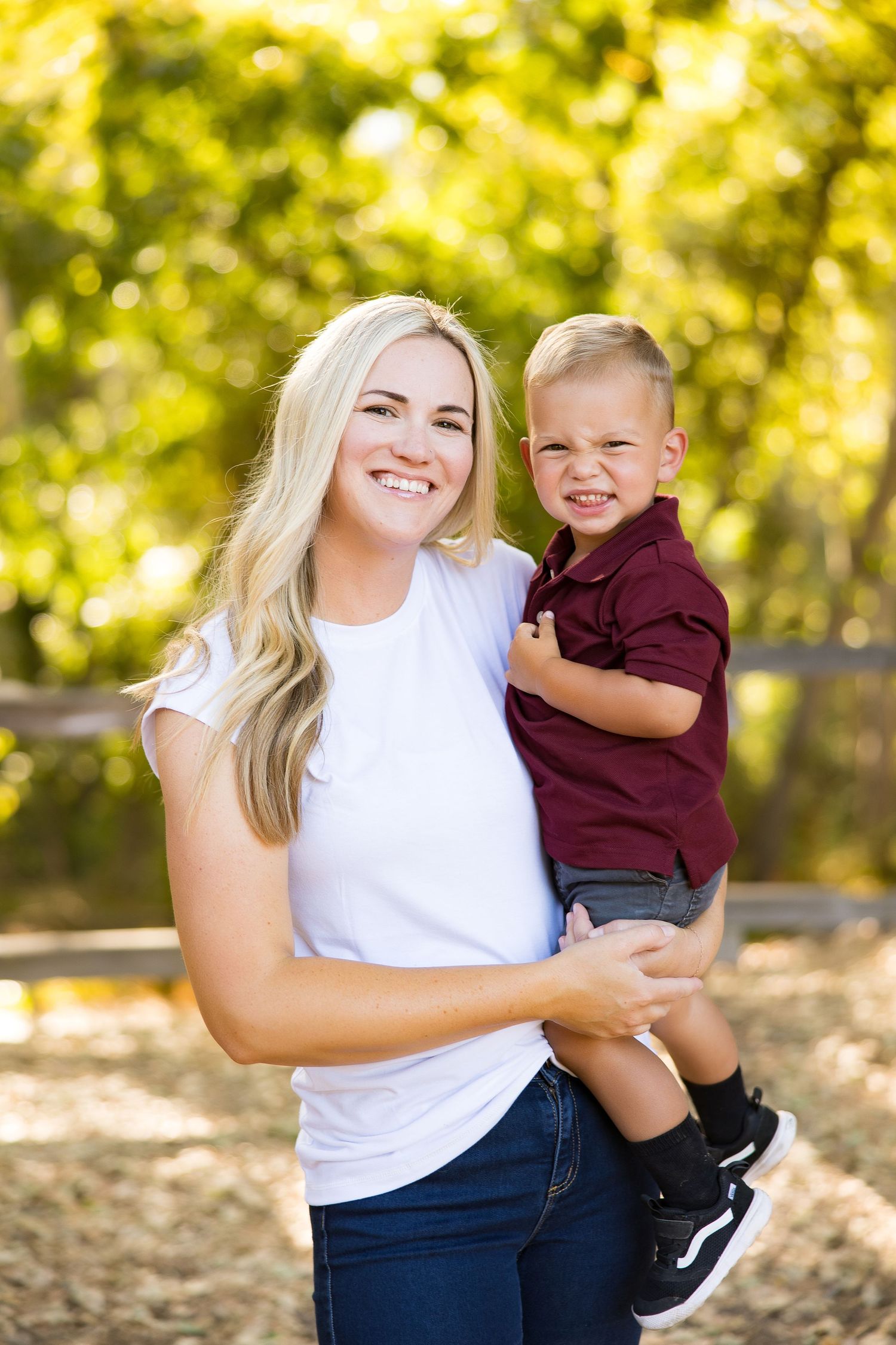 Mother and child sharing joyful moments during outdoor photoshoot.