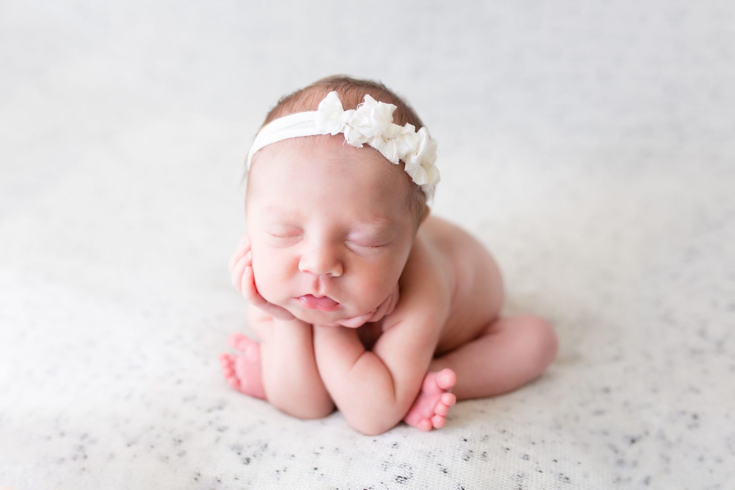 A series of black and white newborn photography shots showing close-up details of tiny hands and feet.