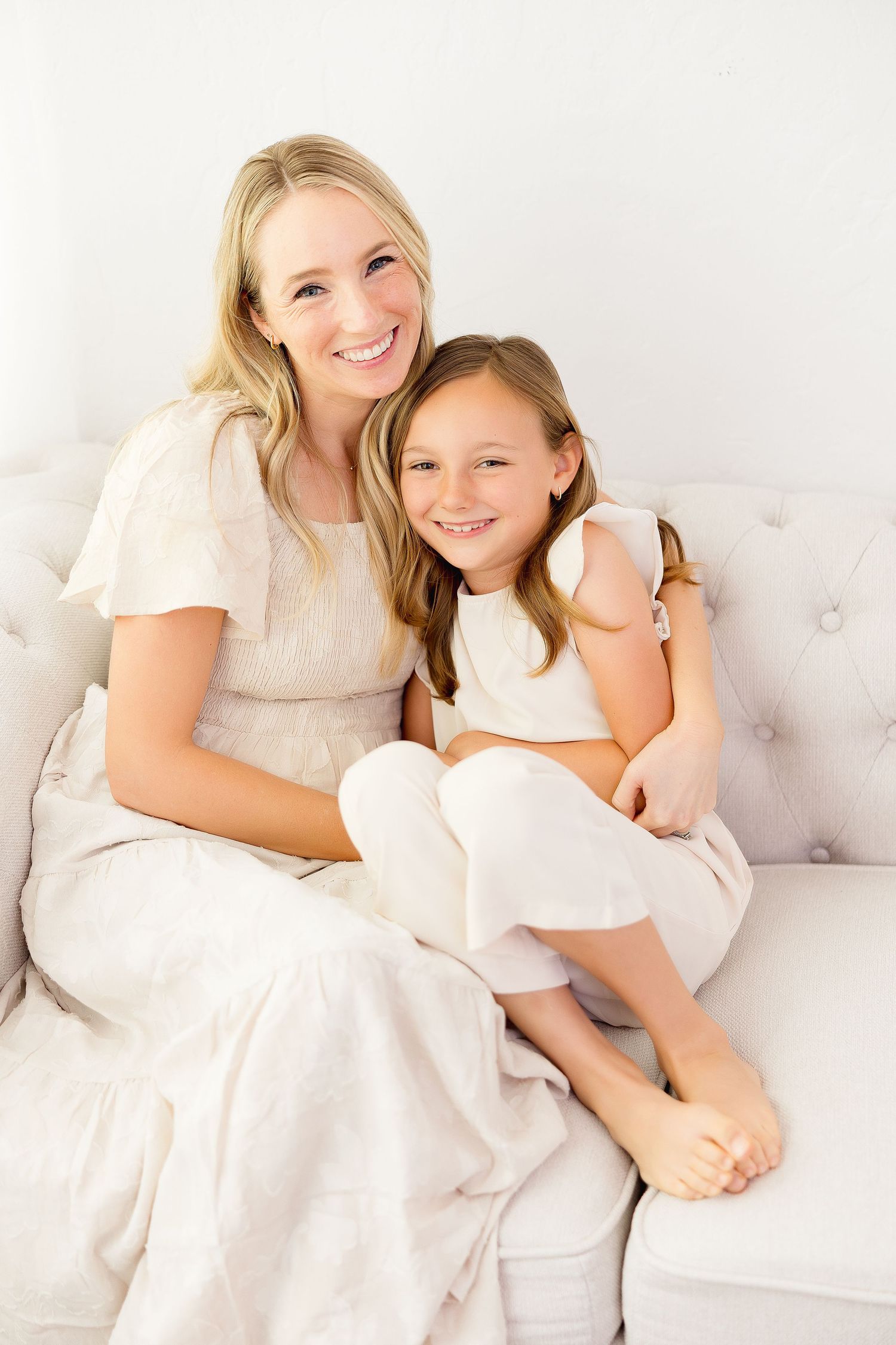 A heartwarming portrait series in soft white tones shows tender moments between a parent and child on a couch.