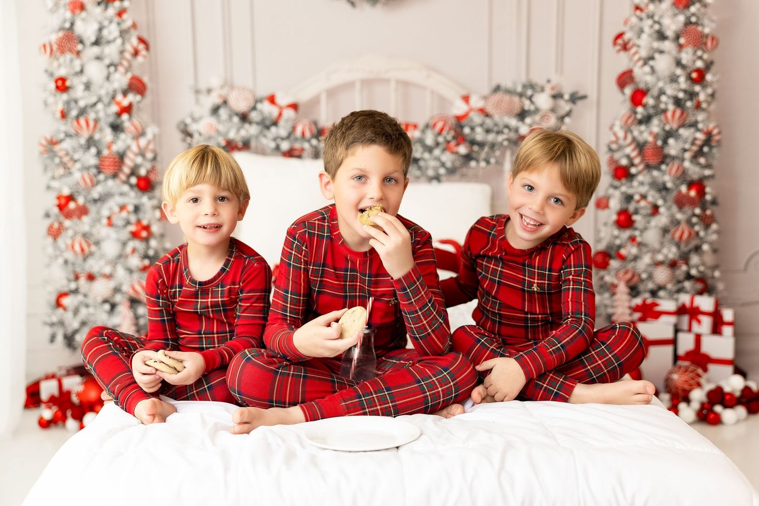 Family Christmas photo session with red plaid pajamas and festive holiday decorations.
