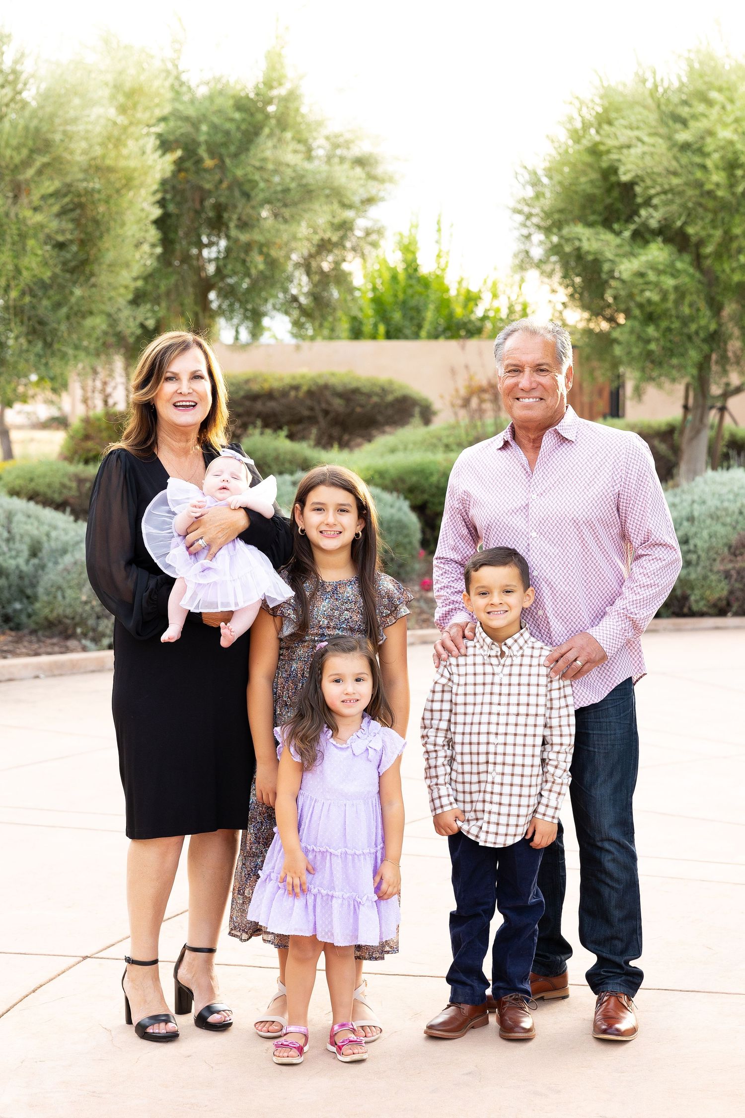 Multi-generational family photo session on a paved walkway in their home