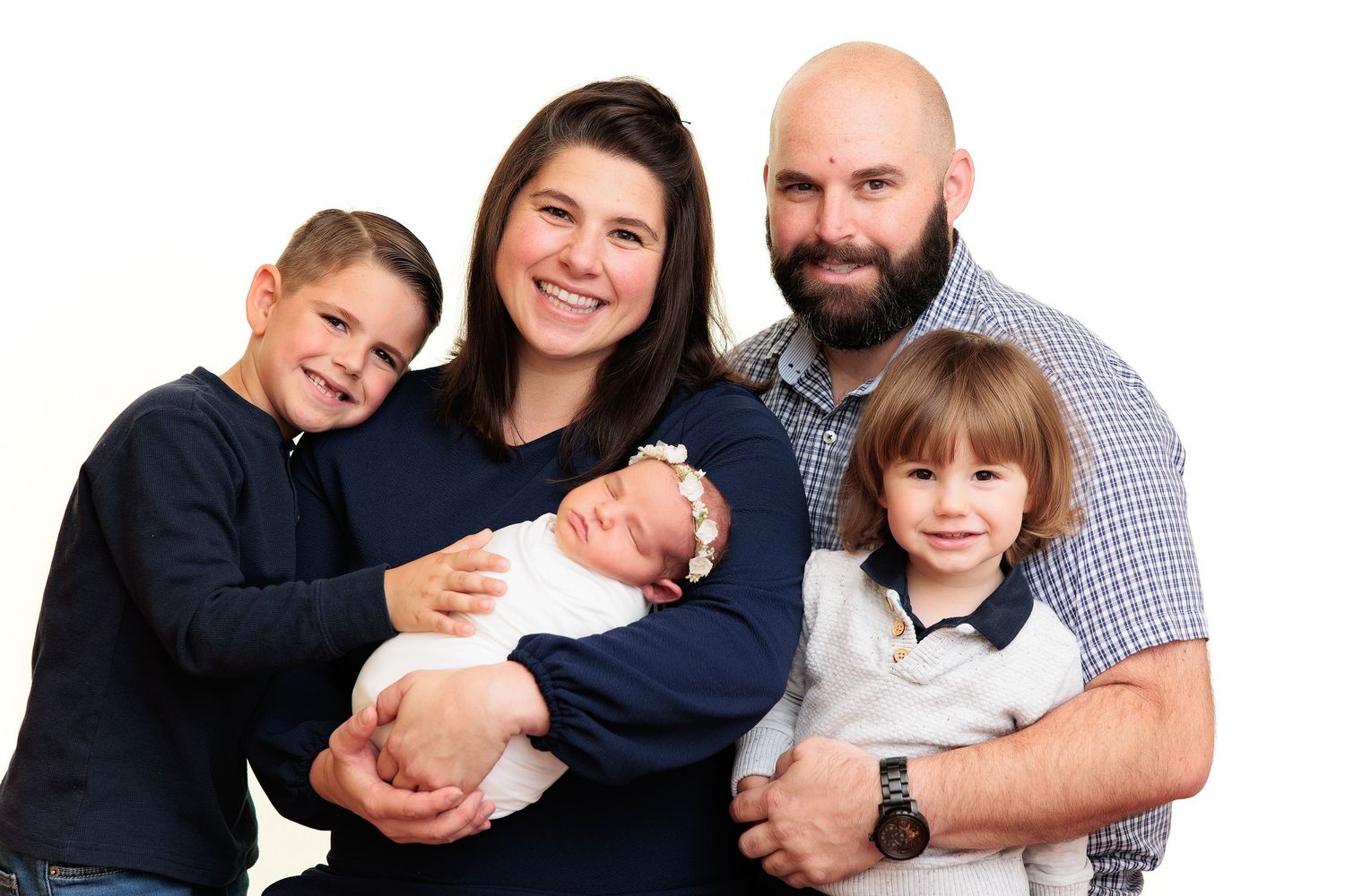 Family of five posing together against light background.