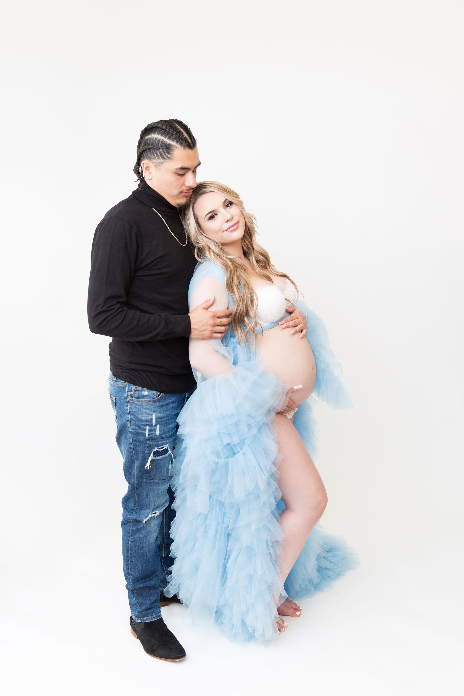 Intimate maternity session with couple in blue tulle dress and casual attire.