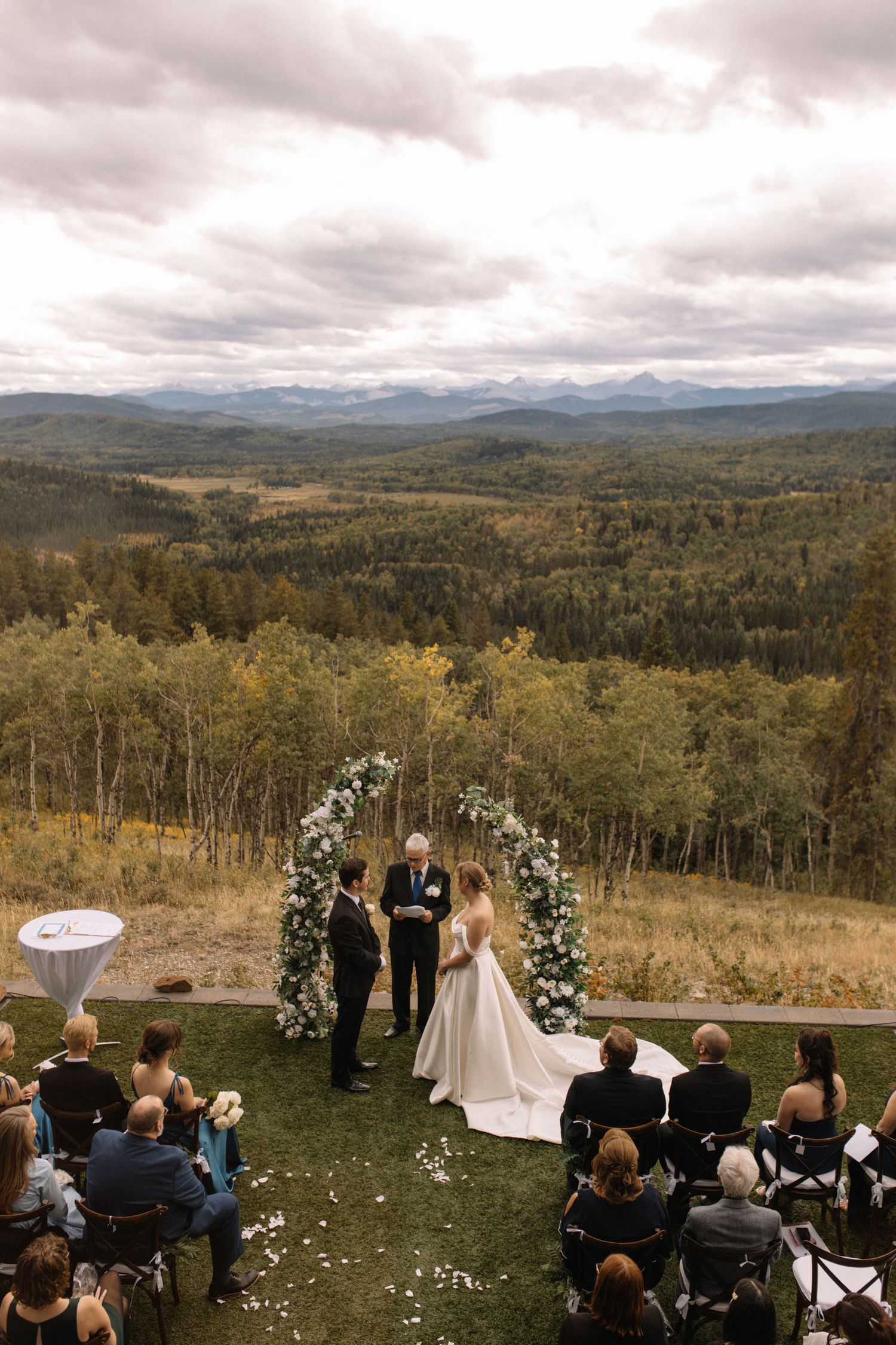 Mountaintop wedding ceremony with panoramic views of forested hills and distant peaks.