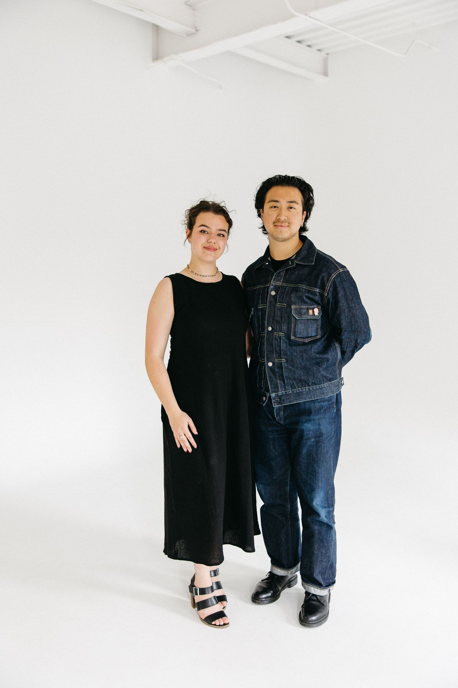 A series of casual portraits showing someone in black dress and another in denim overalls against a white background.