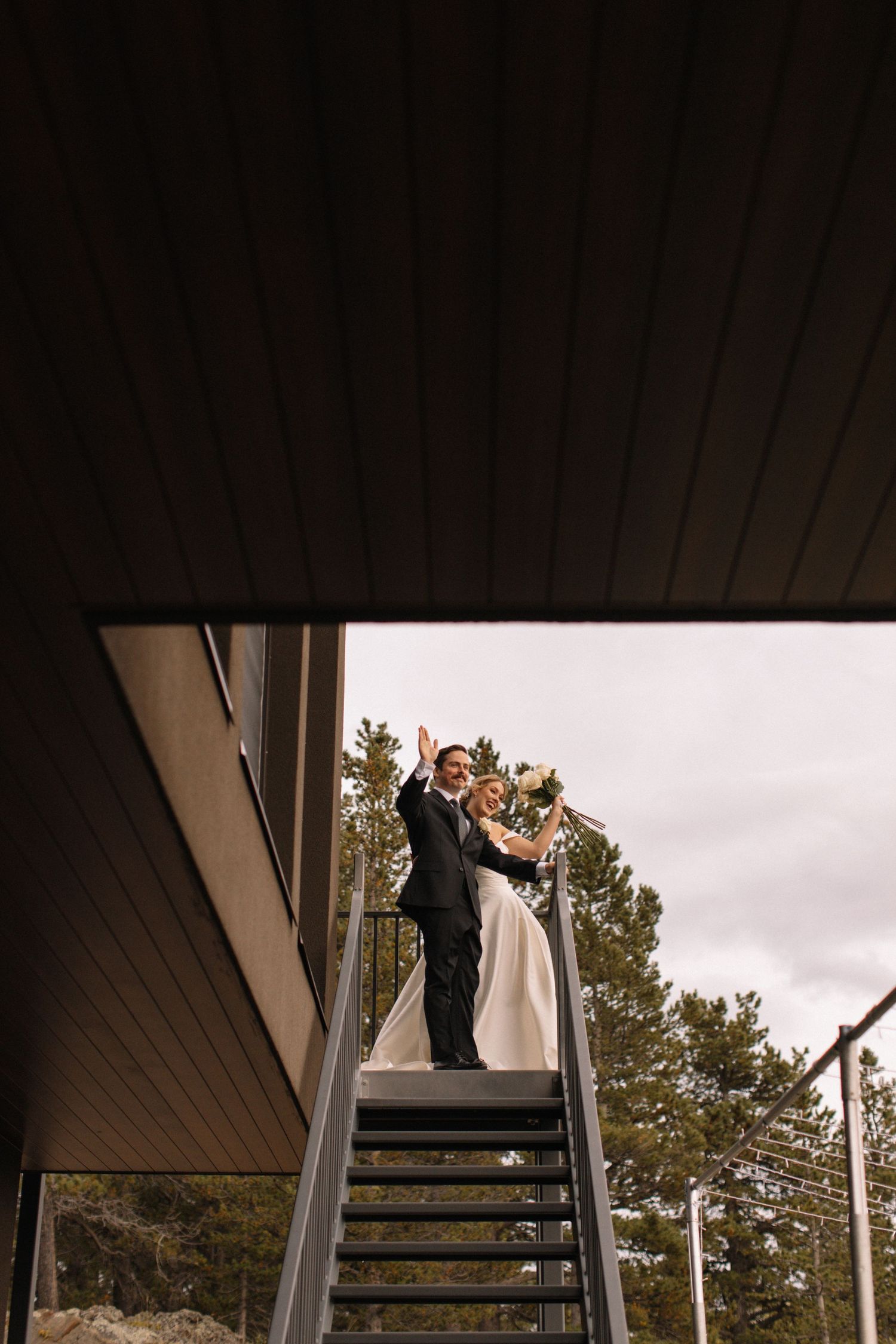 bride and groom waving at guests