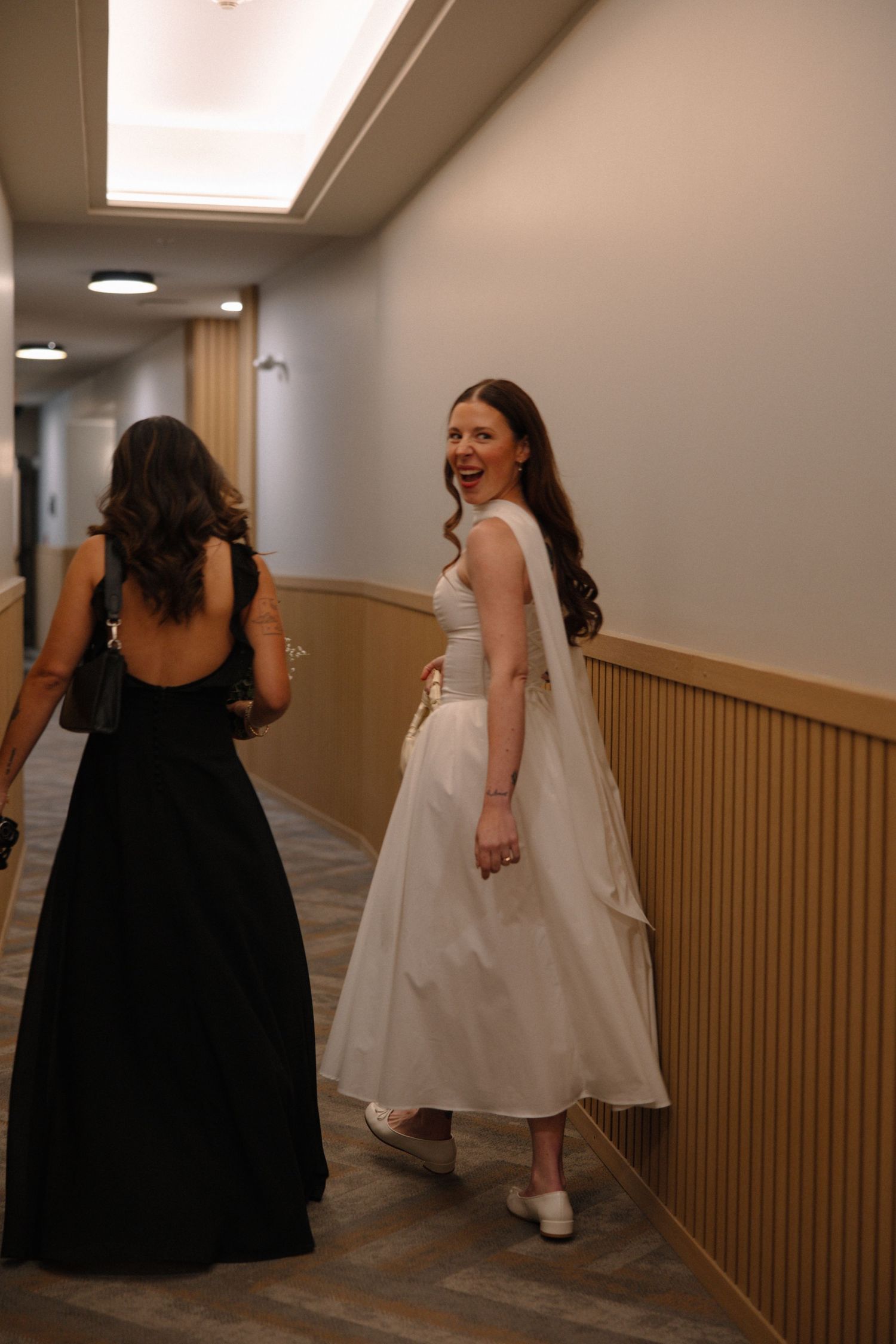 Three sequential photos show people in black and white dresses laughing and walking down a hallway.