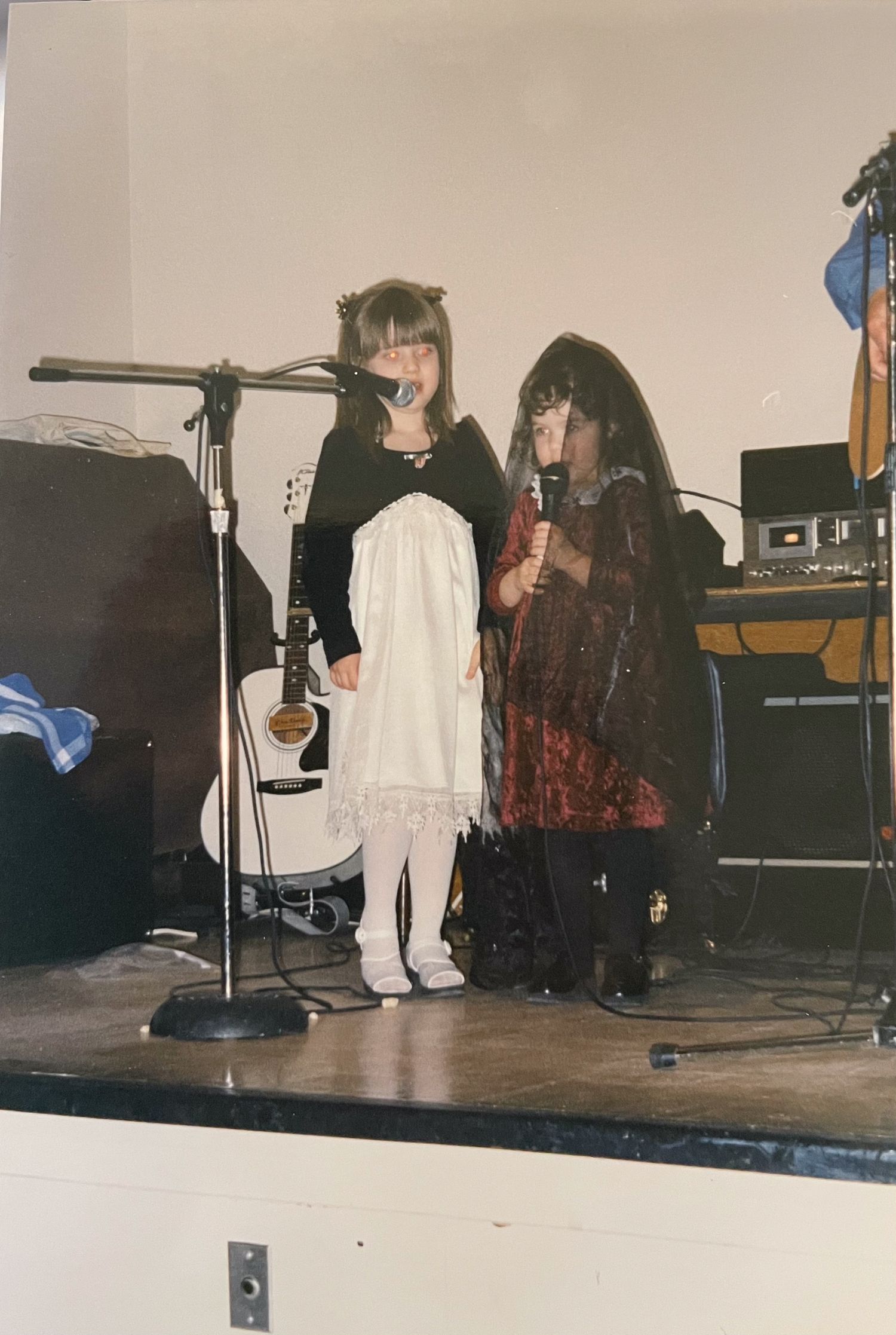 Performance setup on a small stage with microphone stands and musical equipment.