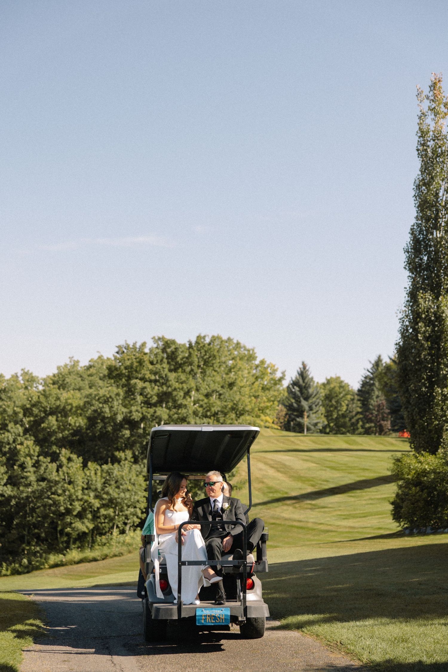 bride and groom in golf cart