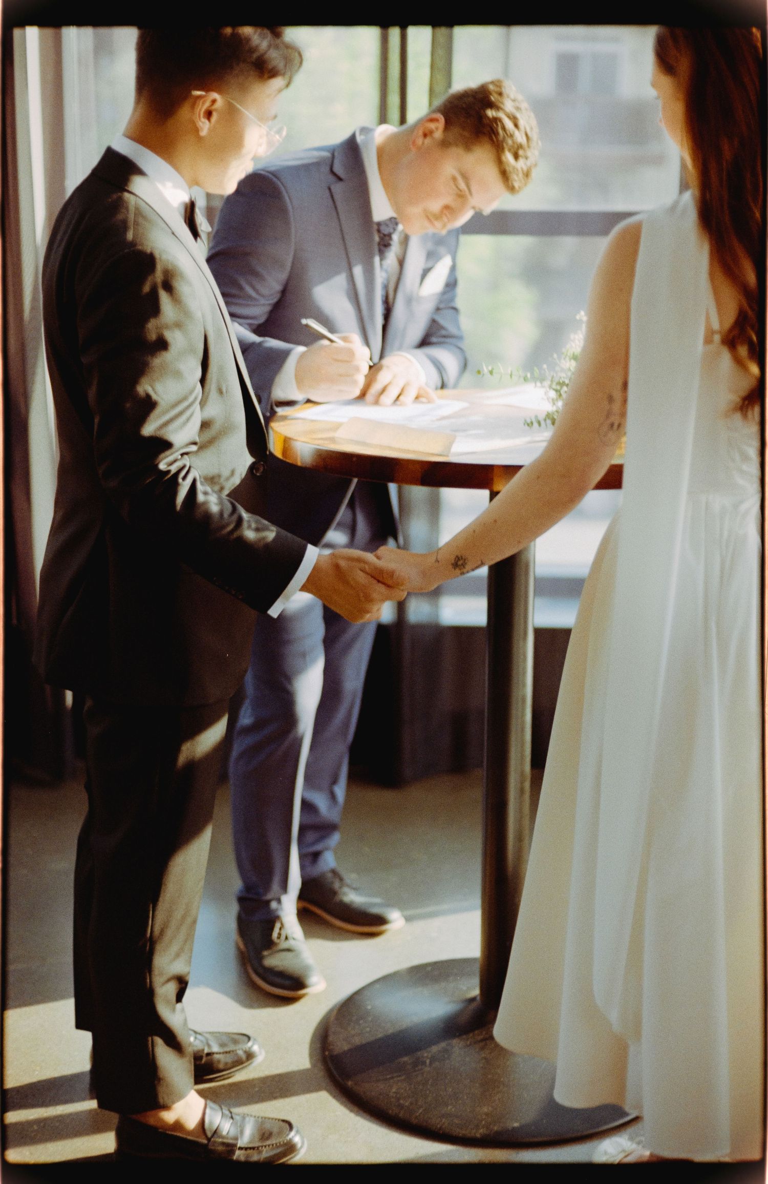 Wedding couple sharing intimate moment near window in modern venue.